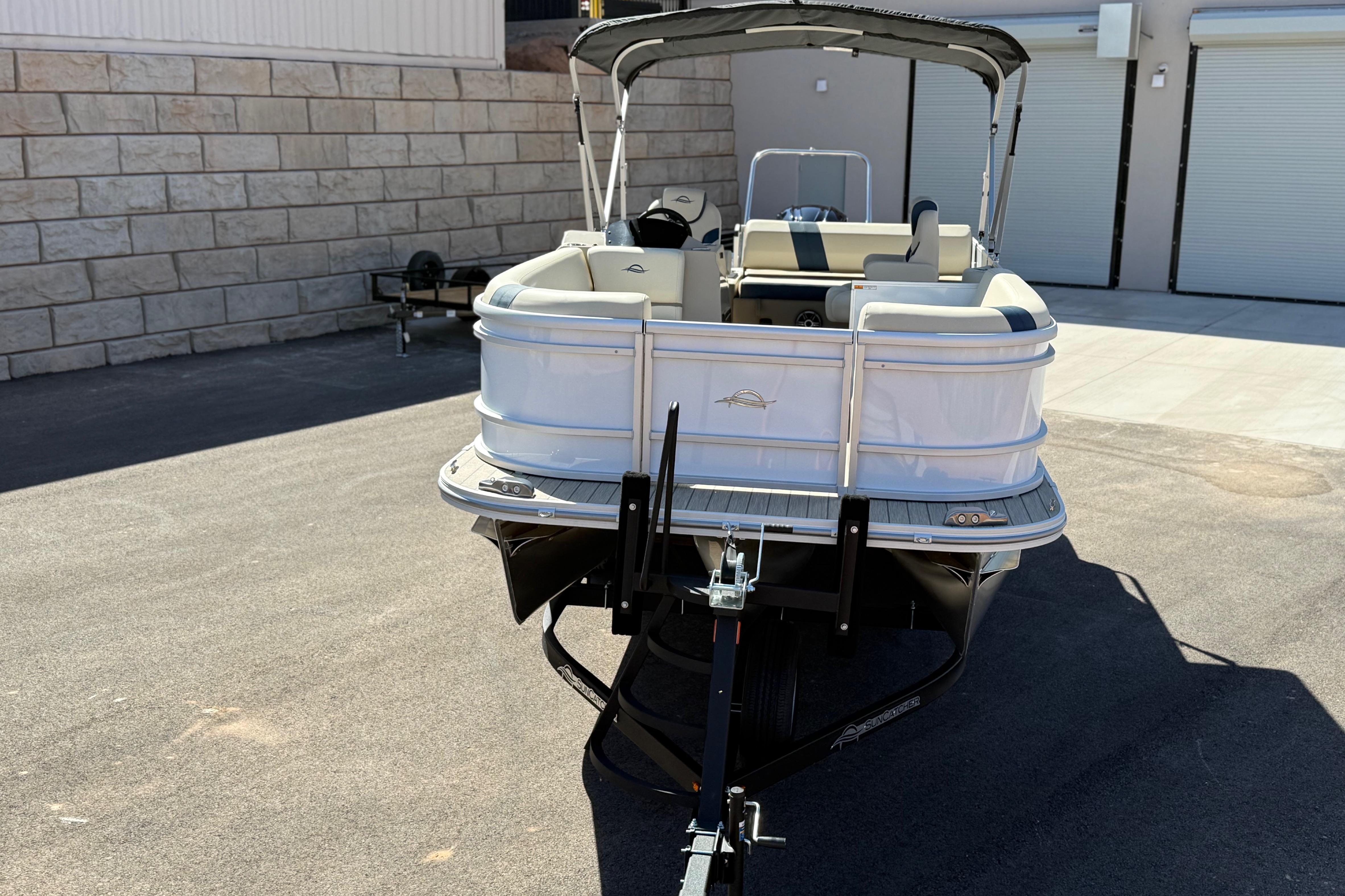 2026 SunCatcher Select 322SL pontoon boat parked on a trailer in a driveway.