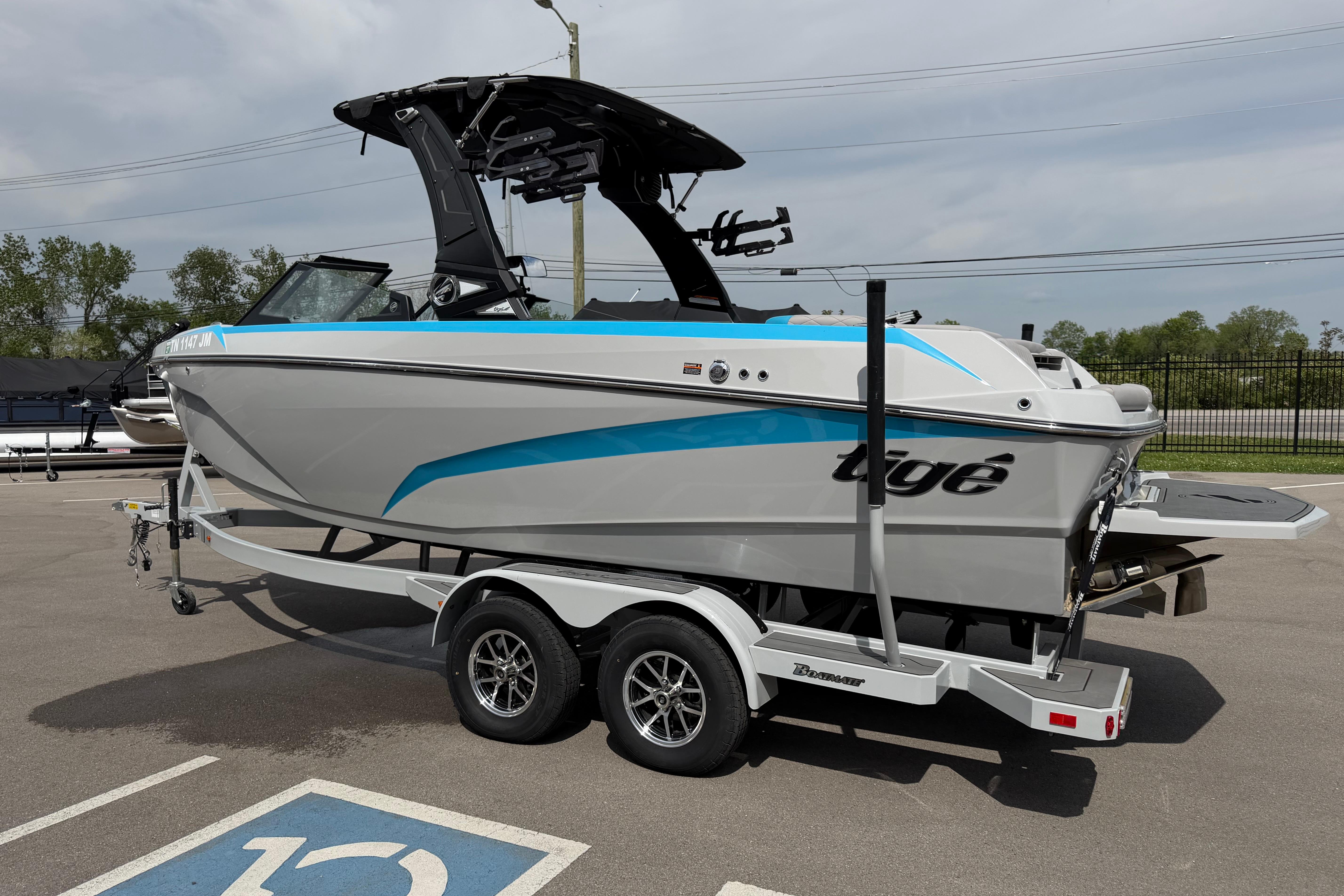 2024 Tigé Z1 boat on trailer, gray with blue accents, parked outdoors.