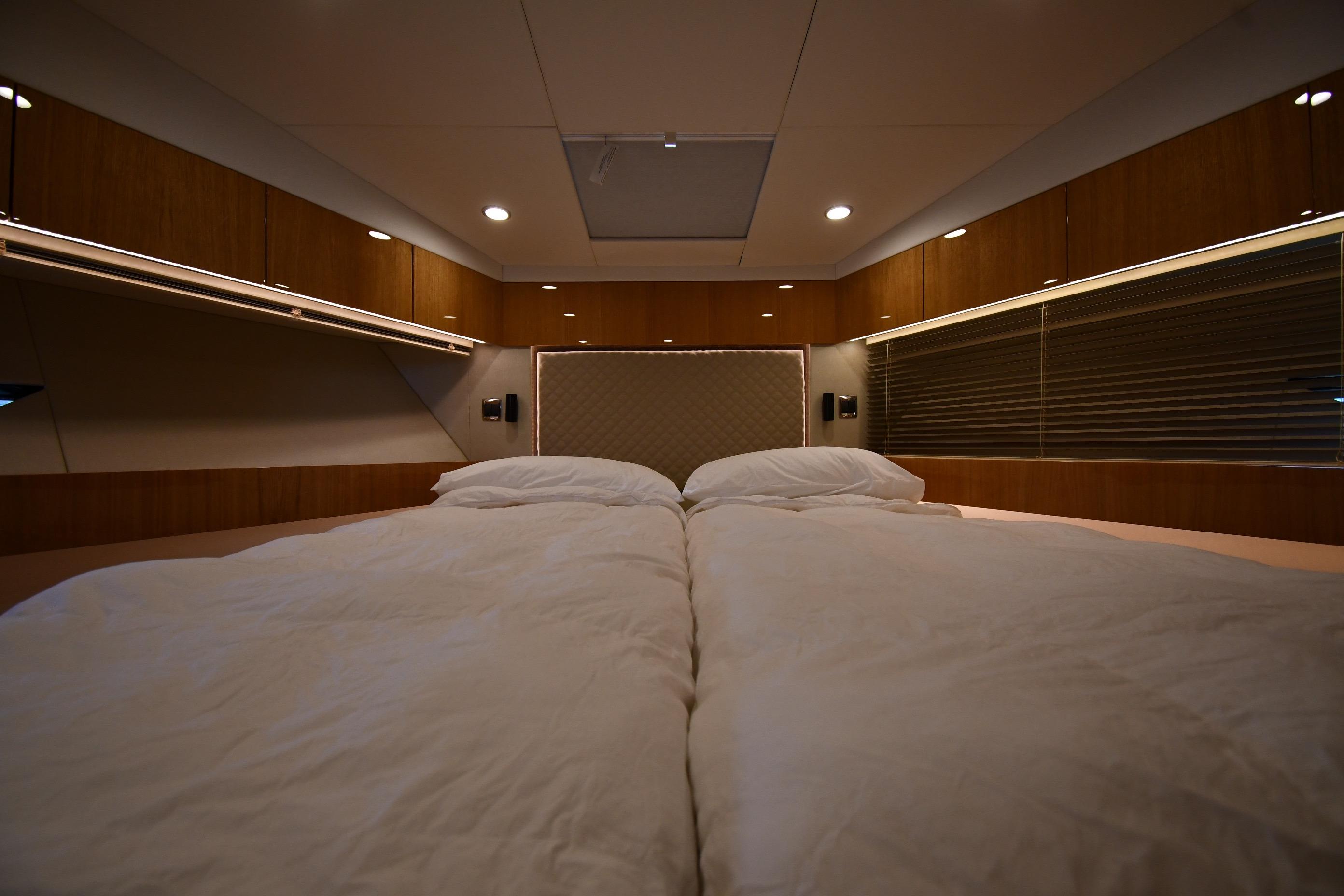 Luxurious cabin interior of 2024 Fairline G50 Targa yacht with cozy bedding.