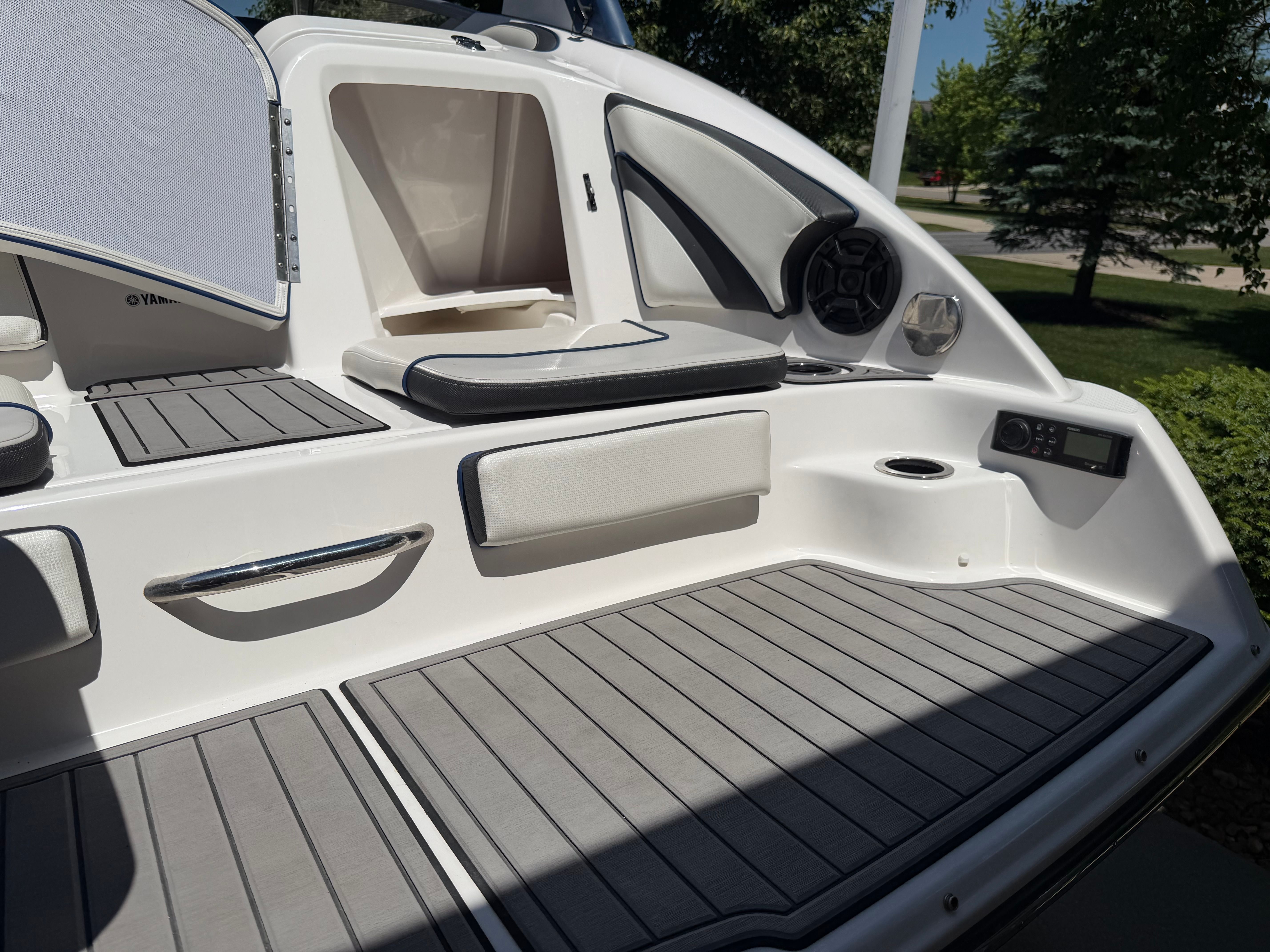 The image shows the stern of a Yamaha 242 Limited S boat with gray cushions and storage compartments.
