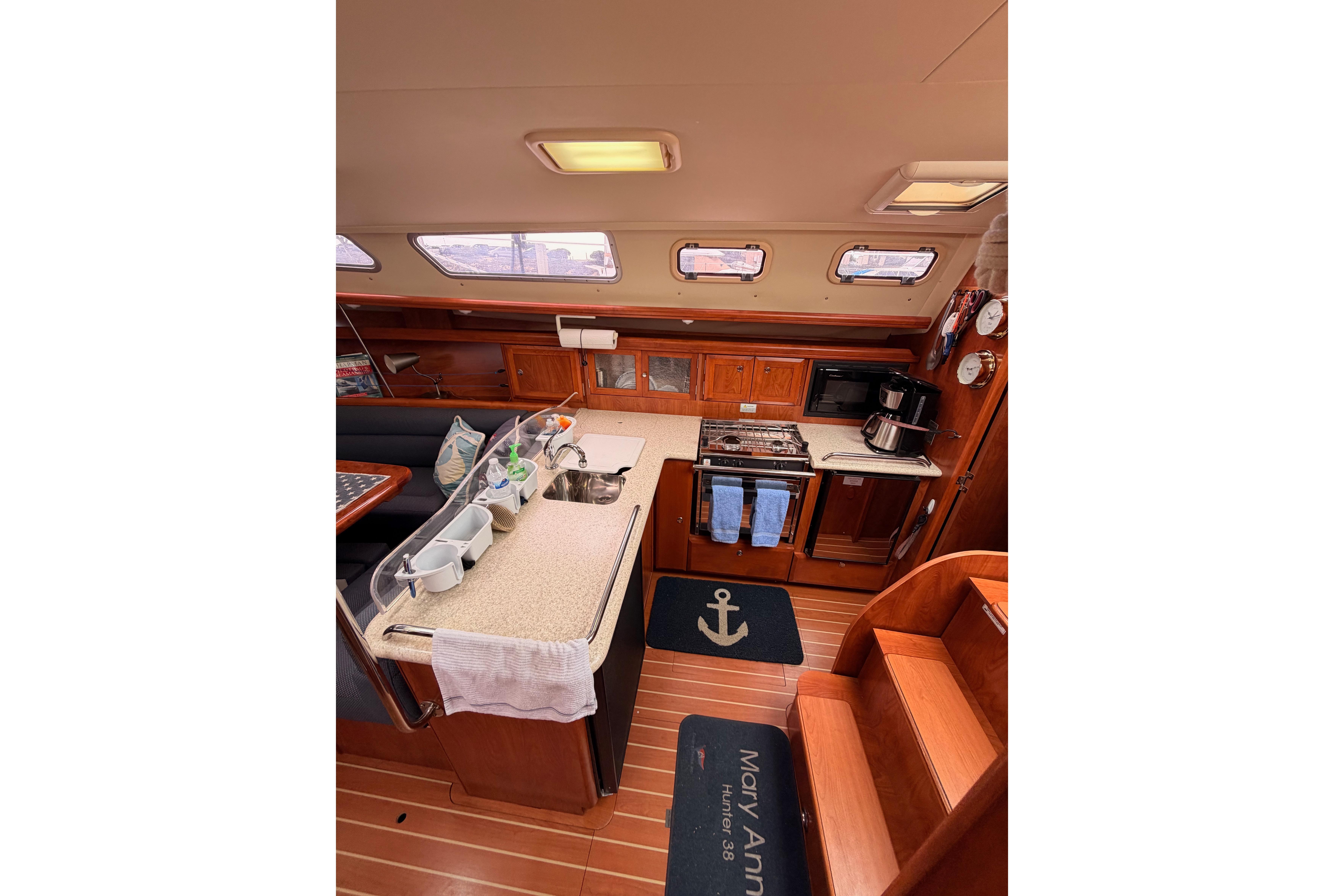 Interior of 2009 Hunter 38 sailboat kitchen with wooden cabinetry and modern appliances.