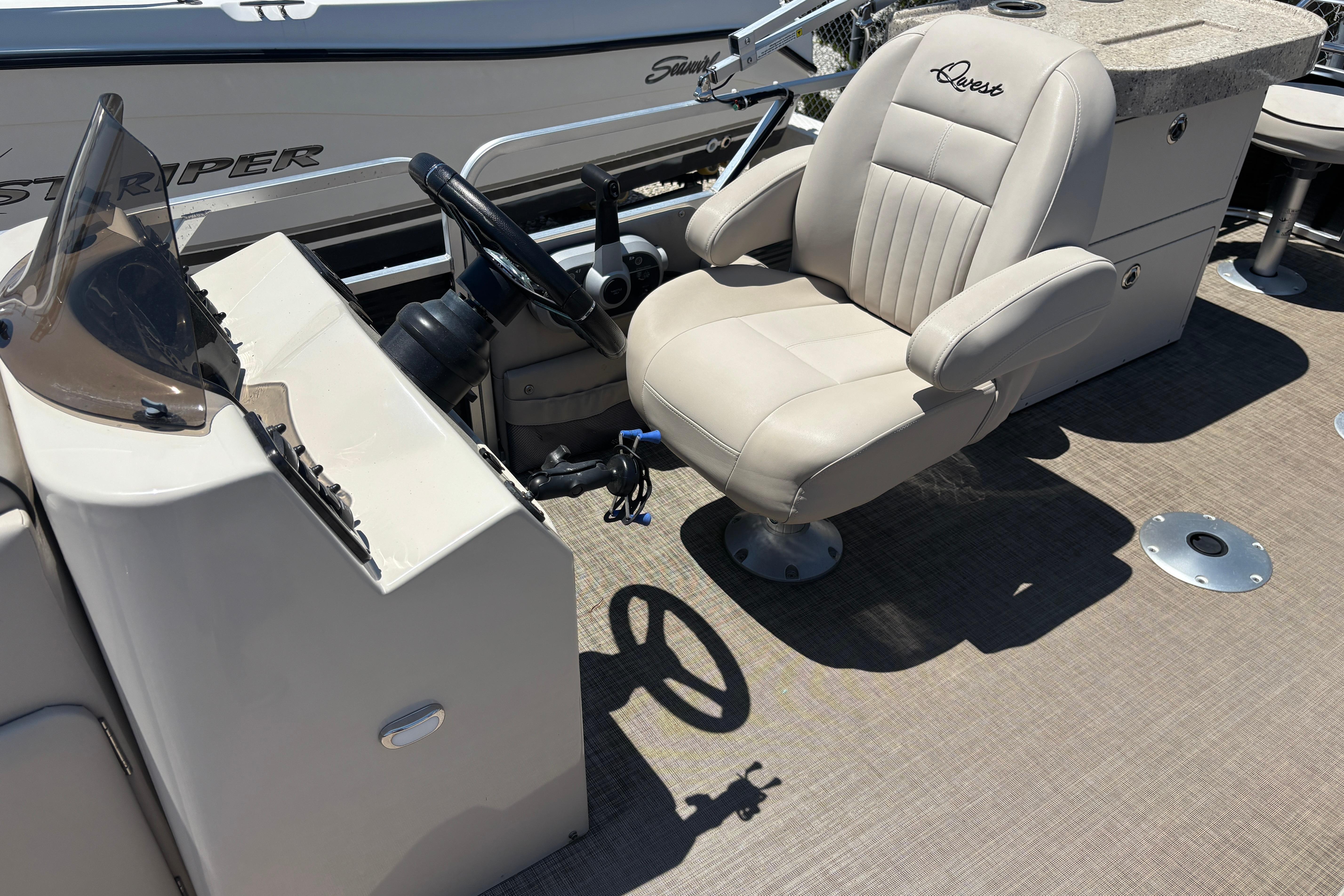 2017 Qwest LS 822 Bar boat interior with beige captain's chair and steering console.