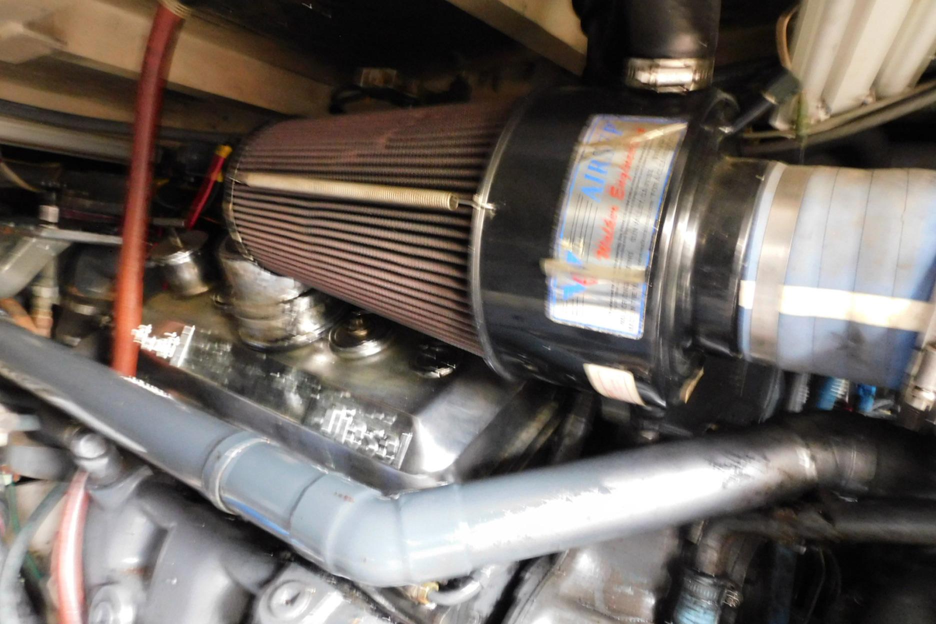 Engine compartment of a 1987 Sea Ray 460 Convertible boat, featuring air filter and piping.