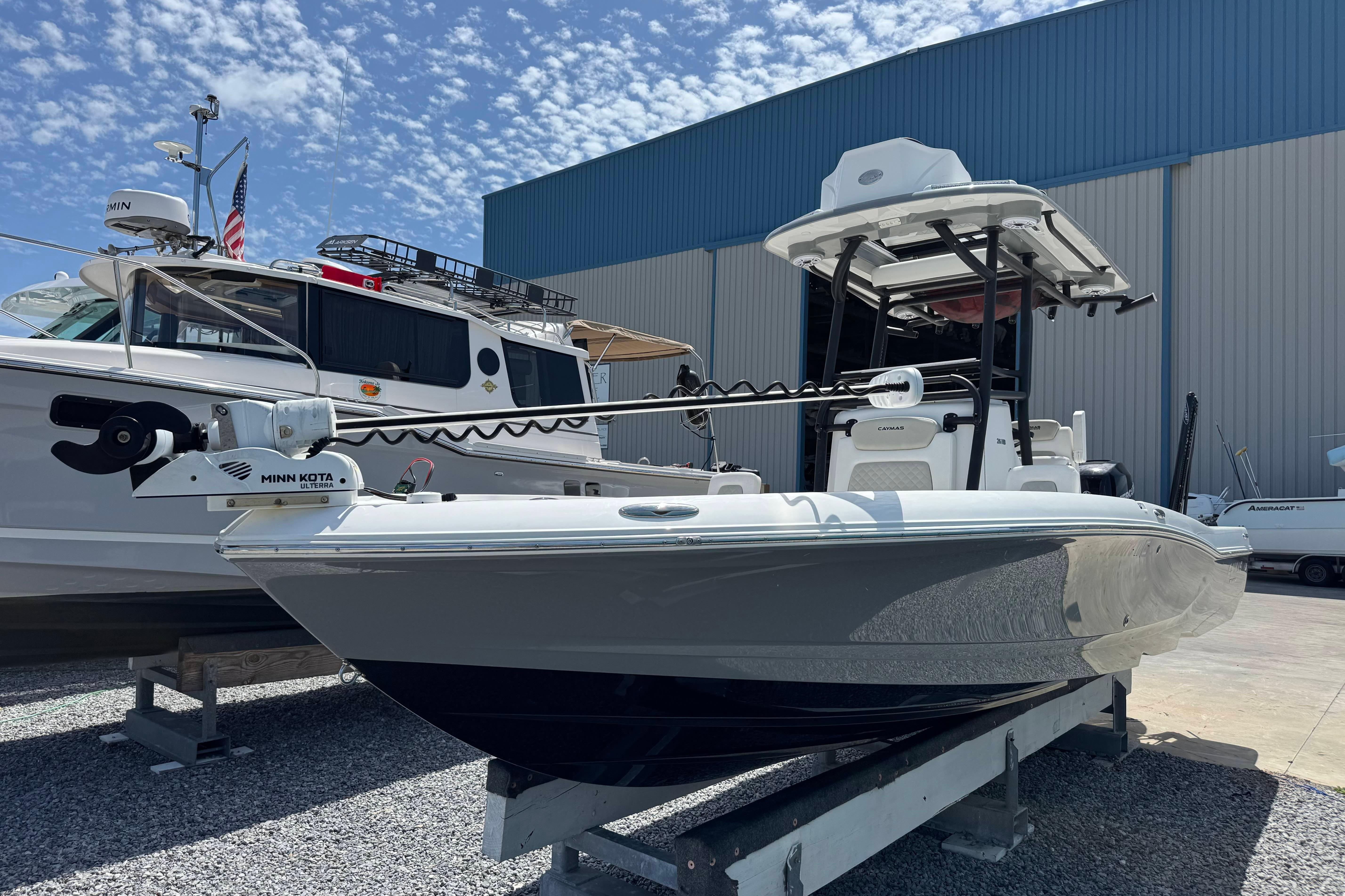 2022 Caymas 26 HB boat on display, featuring Minn Kota trolling motor, in a marina setting.