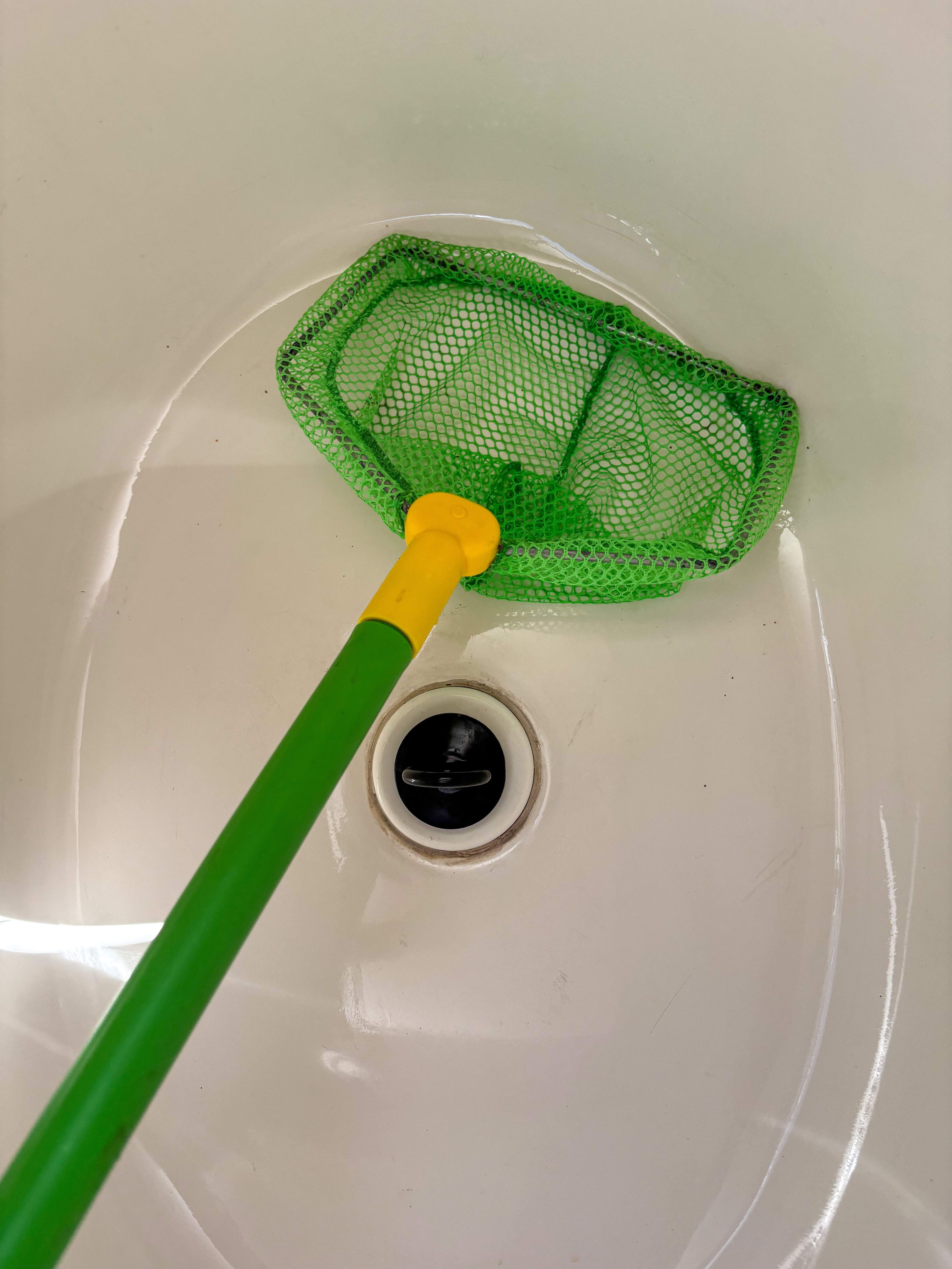 A green net in a white sink.