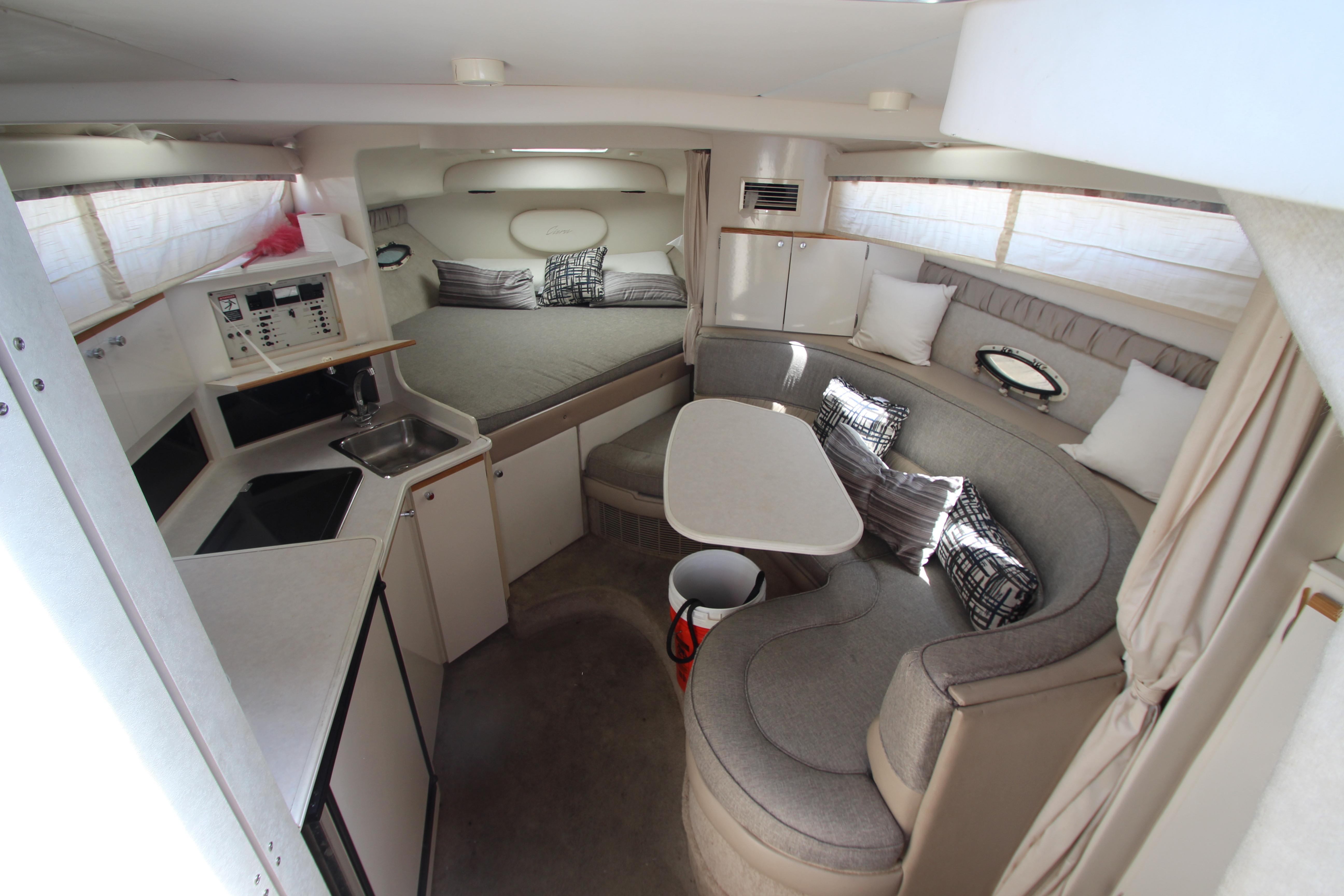 Interior of 1999 Bayliner 3055 Ciera with cozy seating and compact kitchen area.