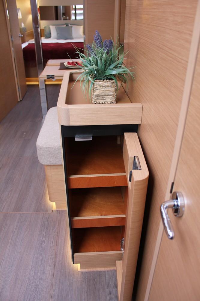 Interior of 2025 Jeanneau Sun Odyssey 440 yacht with modern wooden cabinetry and decor.