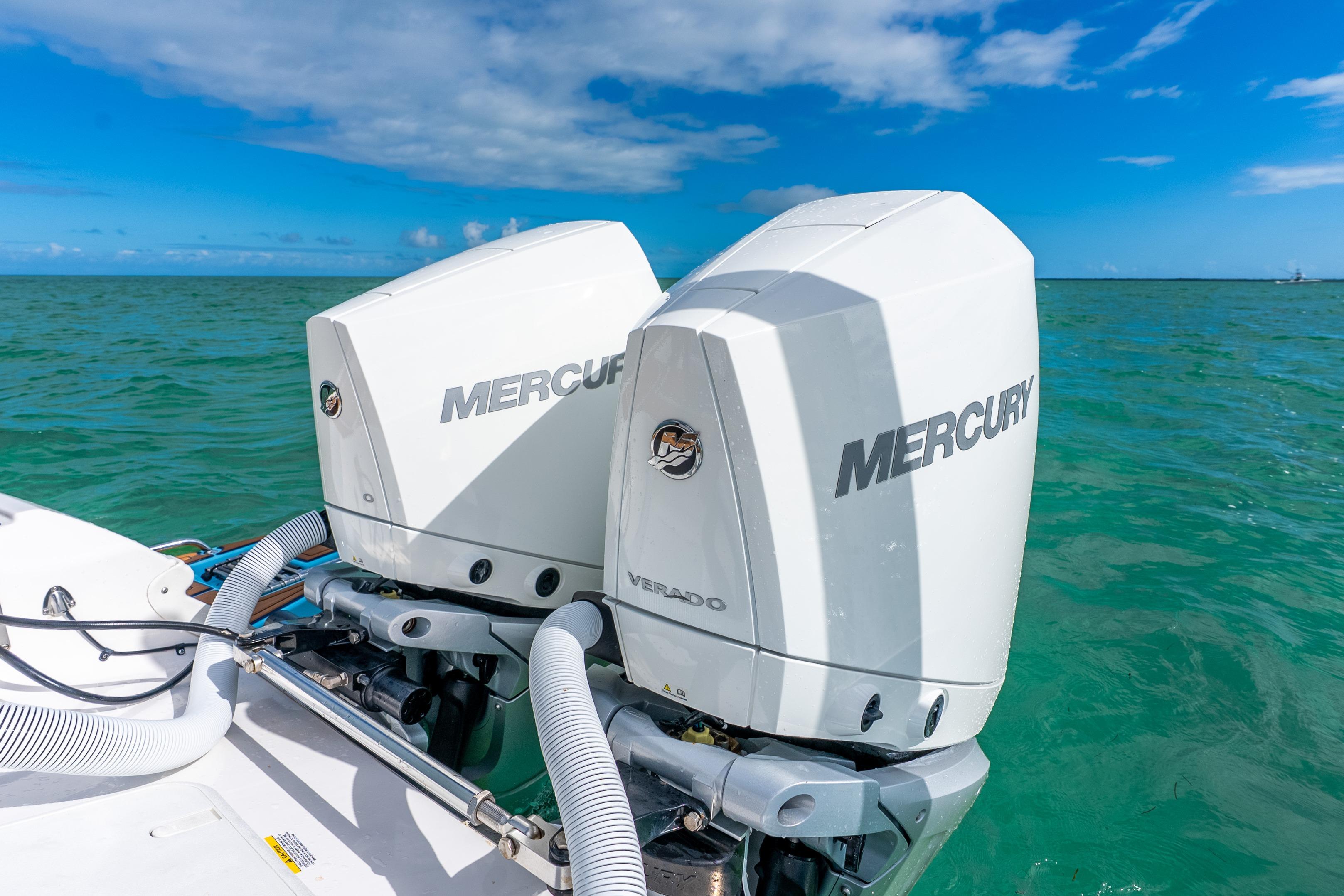 2024 Caymas 281 HB boat with dual Mercury outboard engines on turquoise water.