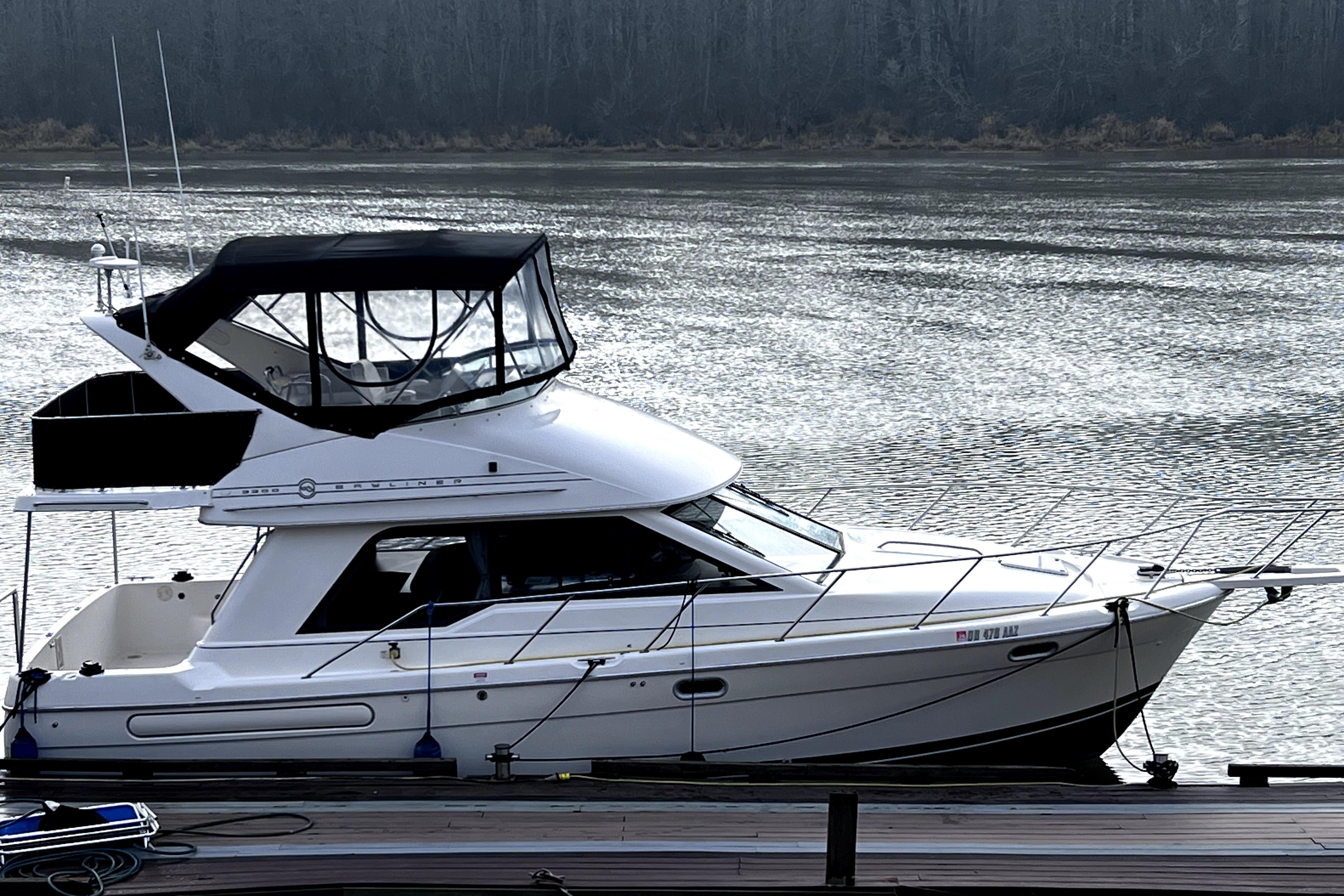 1996 Bayliner 3388 Command Bridge Motoryacht docked on a serene river.