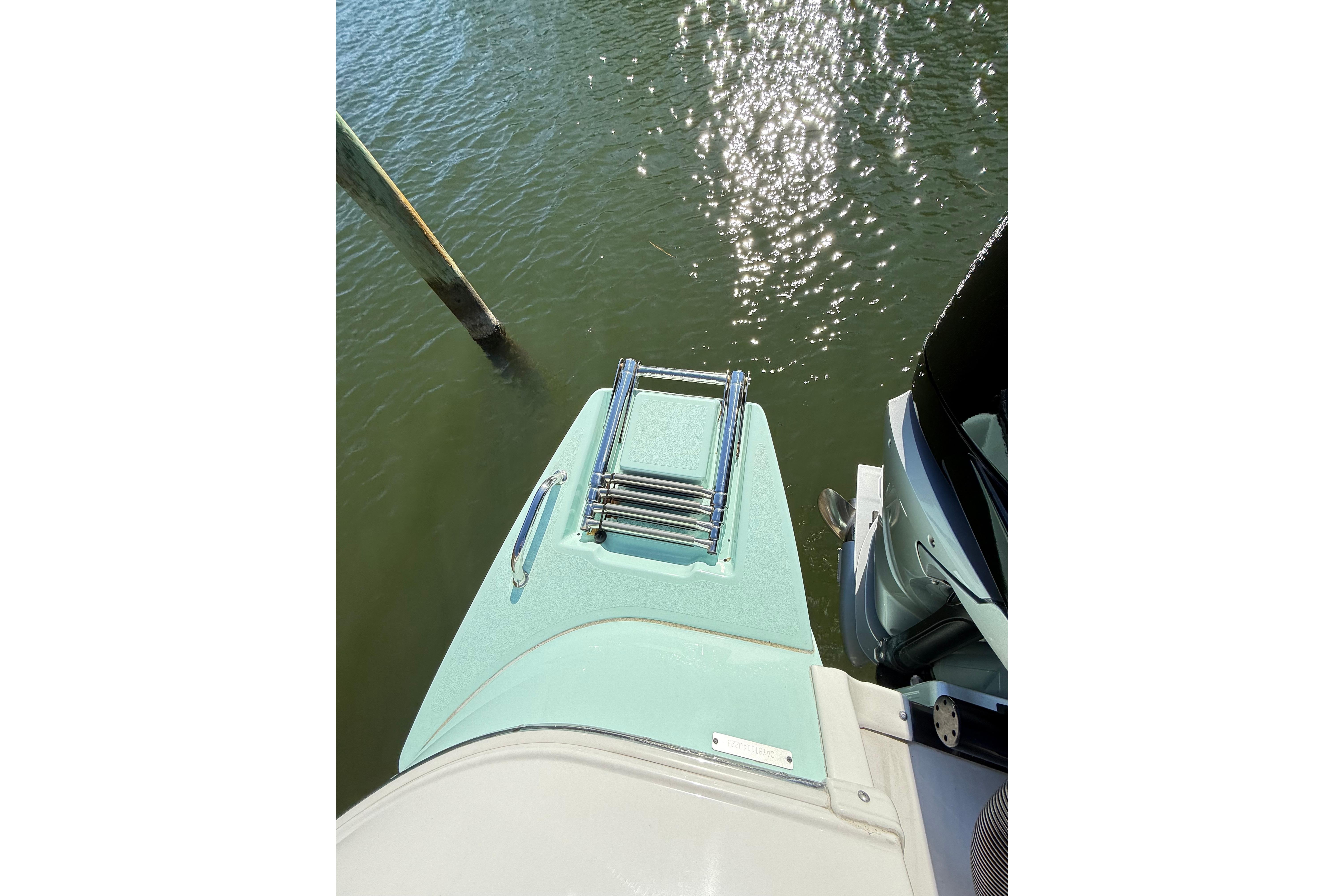 2023 Caymas 281 HB boat with swim platform and ladder on water.