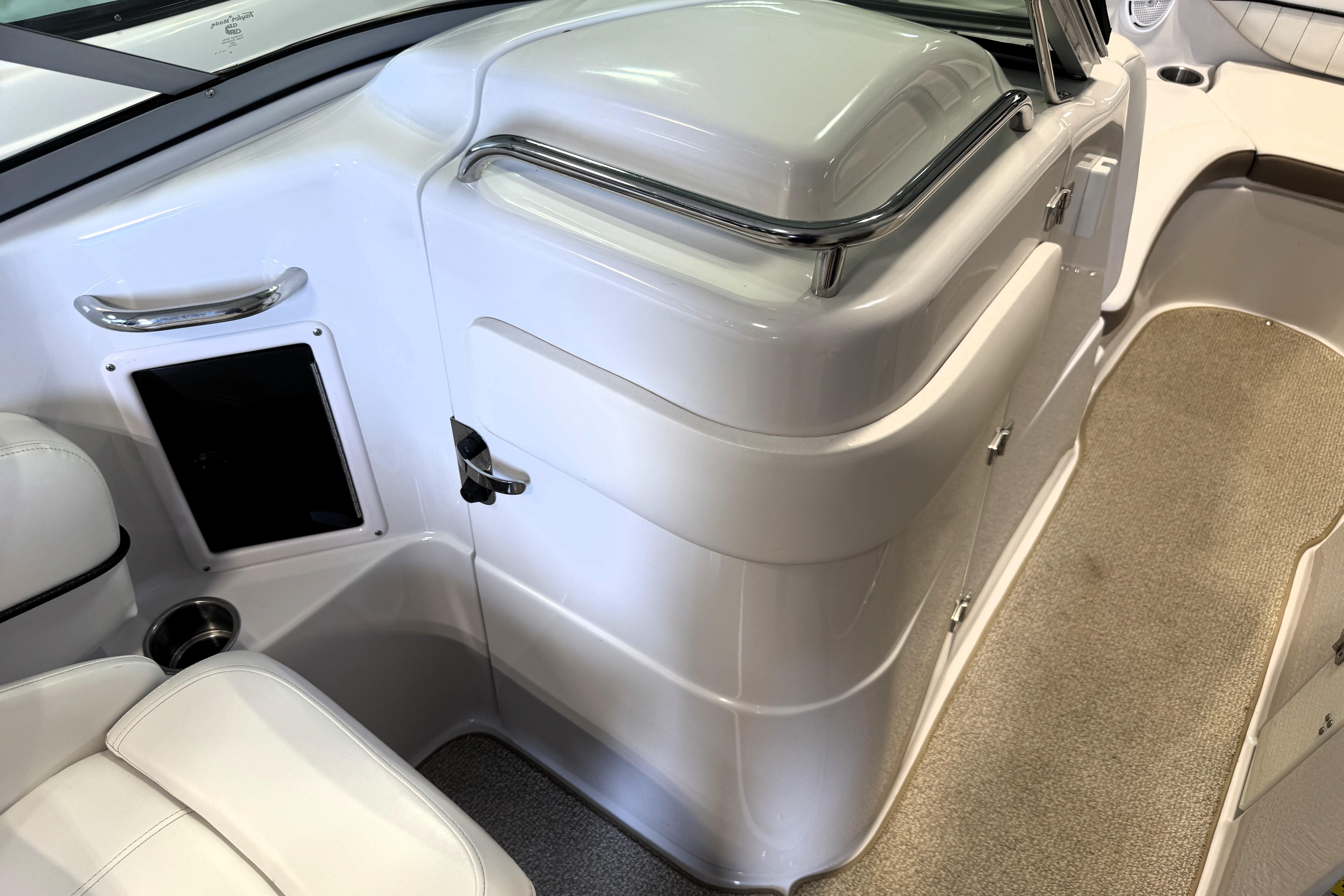 Interior of 2008 Four Winns H240 boat, featuring sleek white seating and storage compartments.