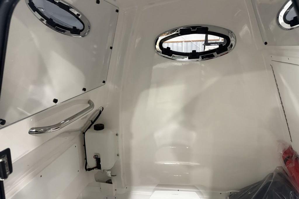 Interior of 2026 Tidewater 3100 Carolina Bay boat with portholes and sleek design.