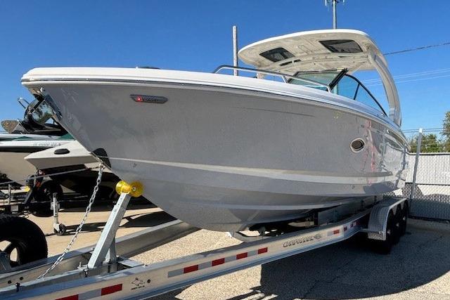 2024 Chaparral 30 Surf boat on trailer, sleek design, sunny day.