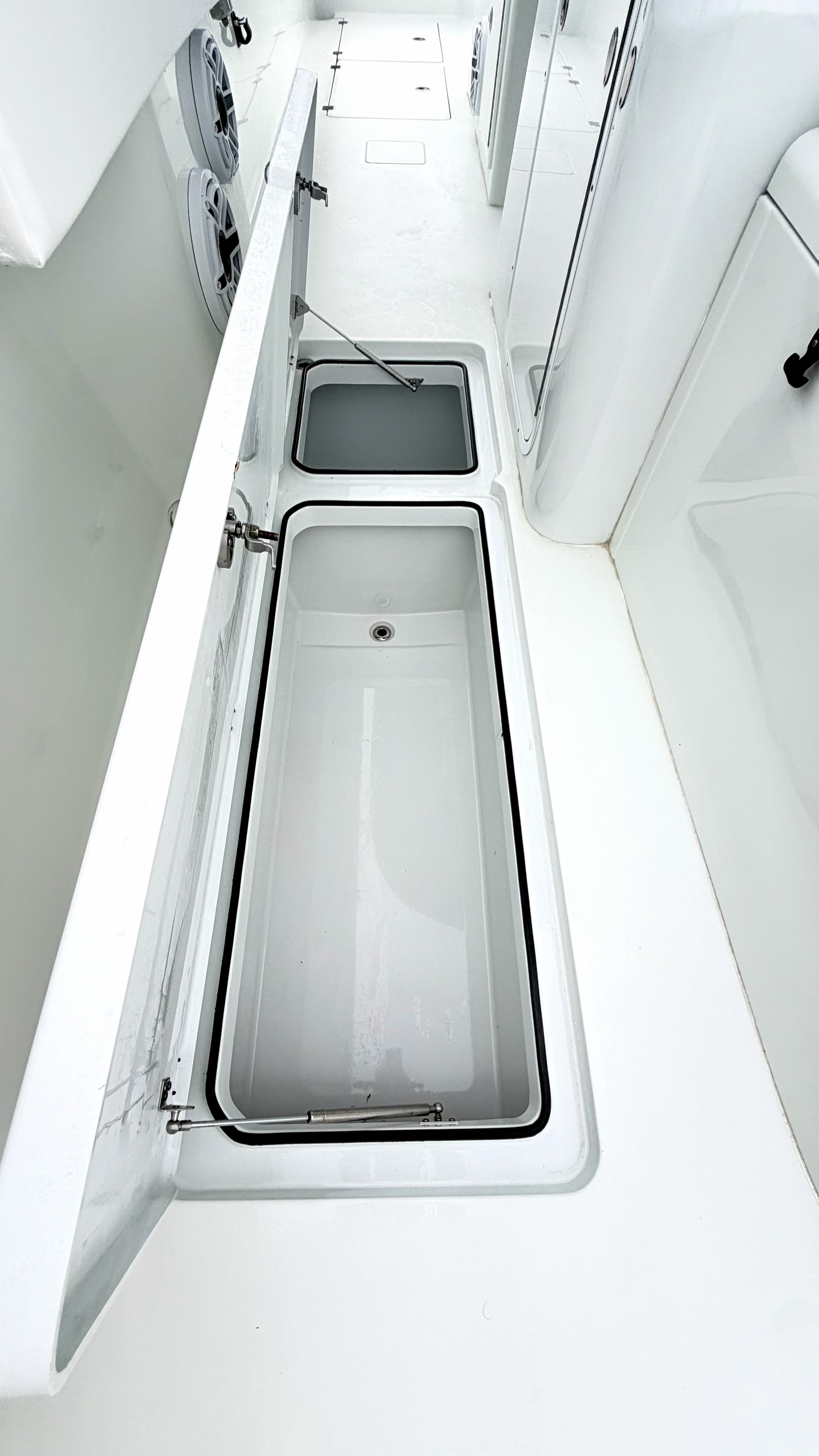 The image shows a boat interior with two open storage compartments.