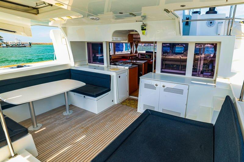 Interior of 2017 Lagoon 450 F catamaran with seating and kitchen area, overlooking the sea.