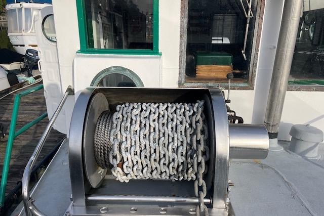 1945 Tug Boat with chain winch on deck, featuring green-trimmed windows.