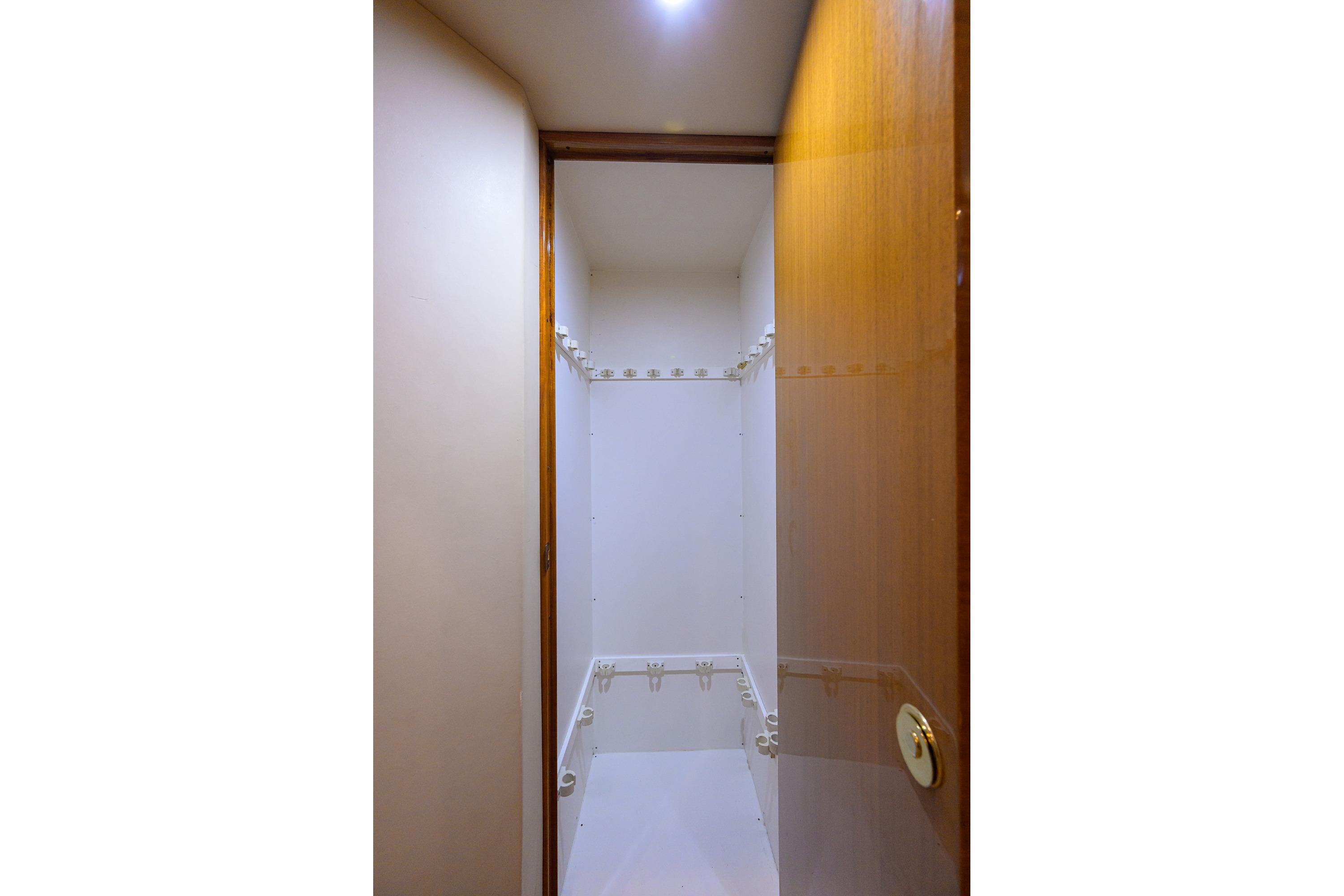 Interior view of a 2004 Viking 48 Convertible yacht's storage closet with wooden door.
