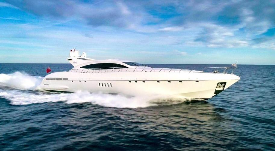 Luxurious 2004 Mangusta 108 yacht cruising on open sea under clear blue sky.