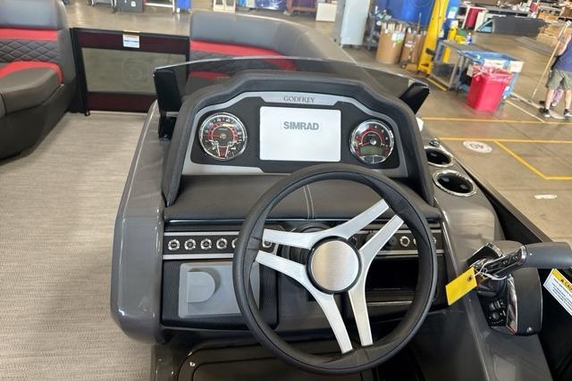 Cockpit of 2027 Godfrey Monaco 25' Tritoon with steering wheel and Simrad display.