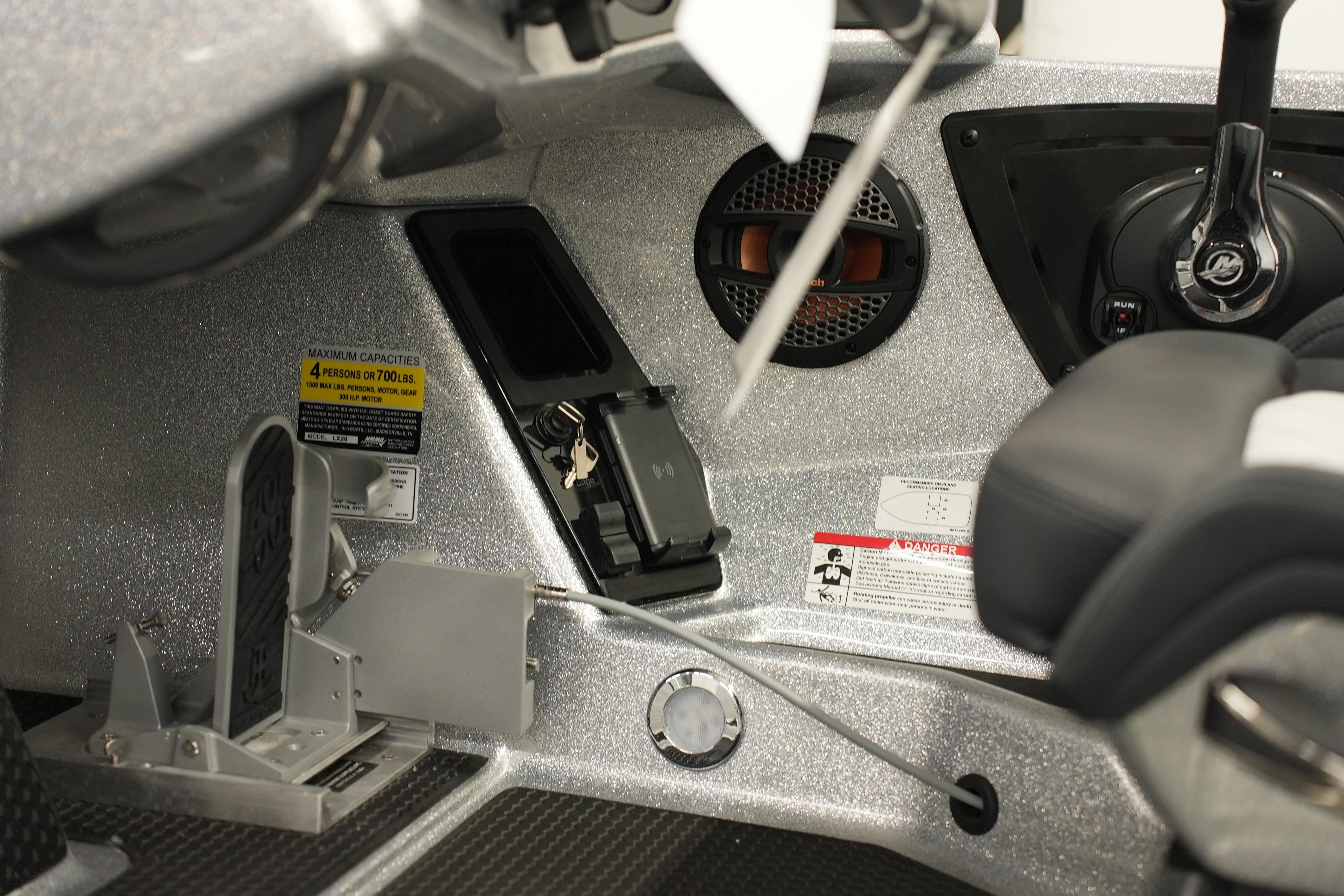 Interior of 2026 iKon LXE20 boat showing controls, speaker, and capacity label.