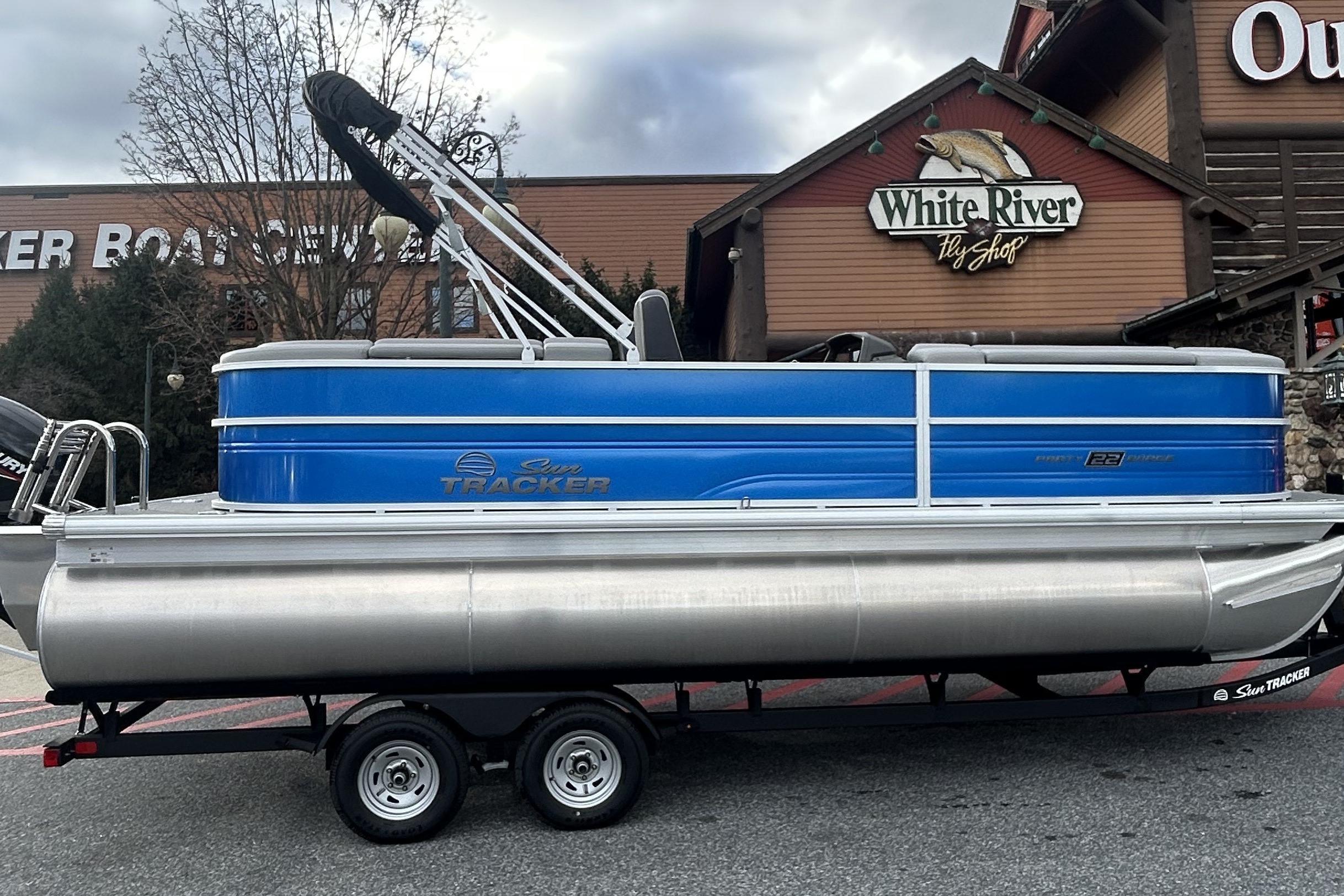 2026 Sun Tracker Party Barge 22 XP3 pontoon boat parked outside White River Fly Shop.