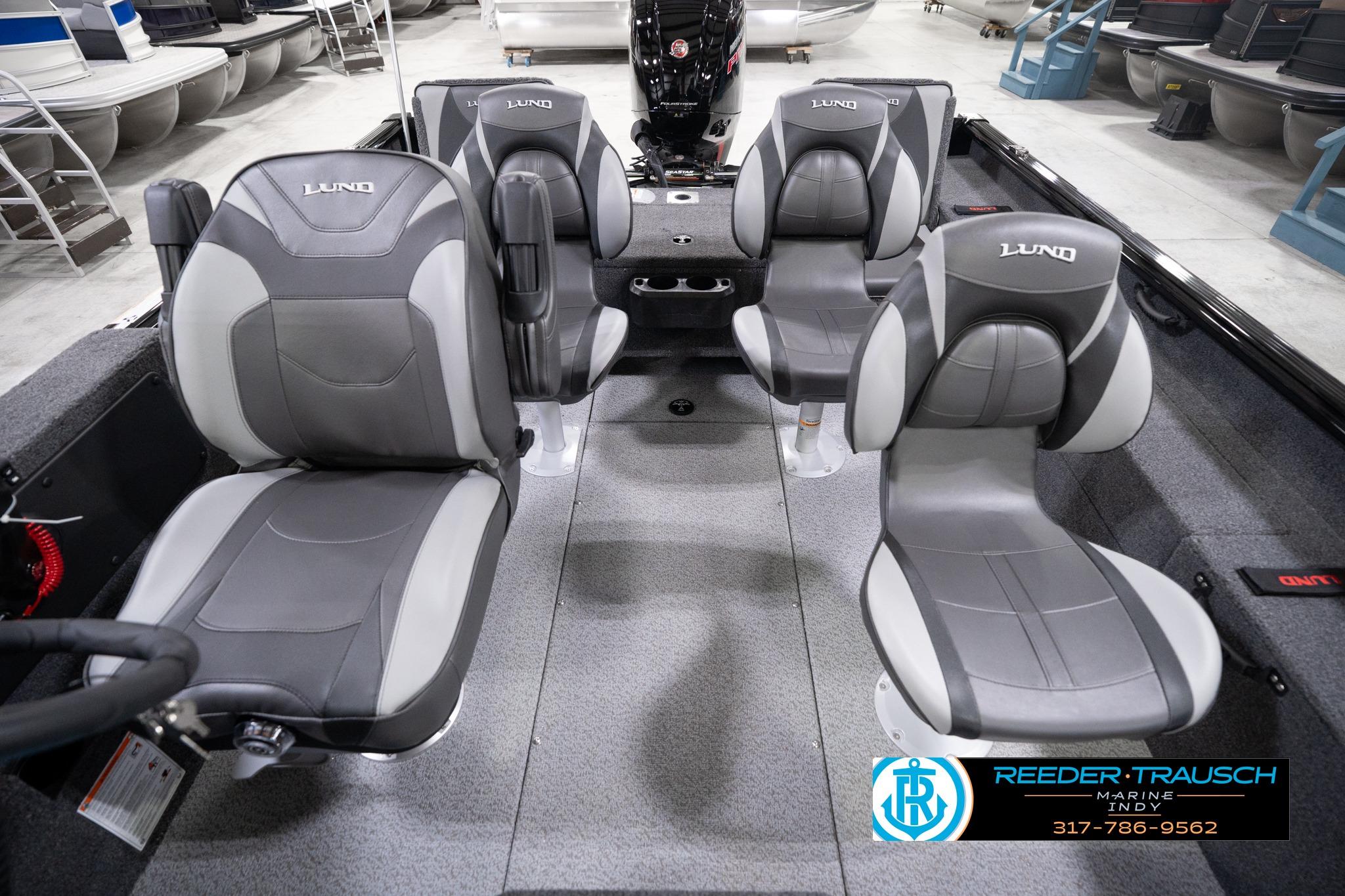 2026 Lund 1775 Impact XS SS boat interior with four gray seats in showroom.