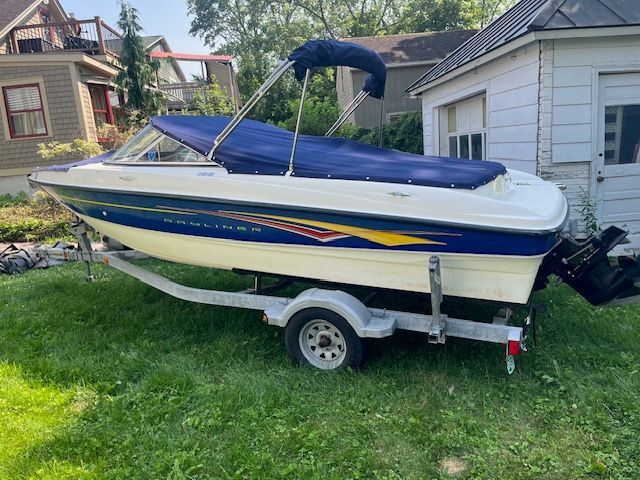 A 2007 Bayliner 185 boat on a trailer in a garden setting.