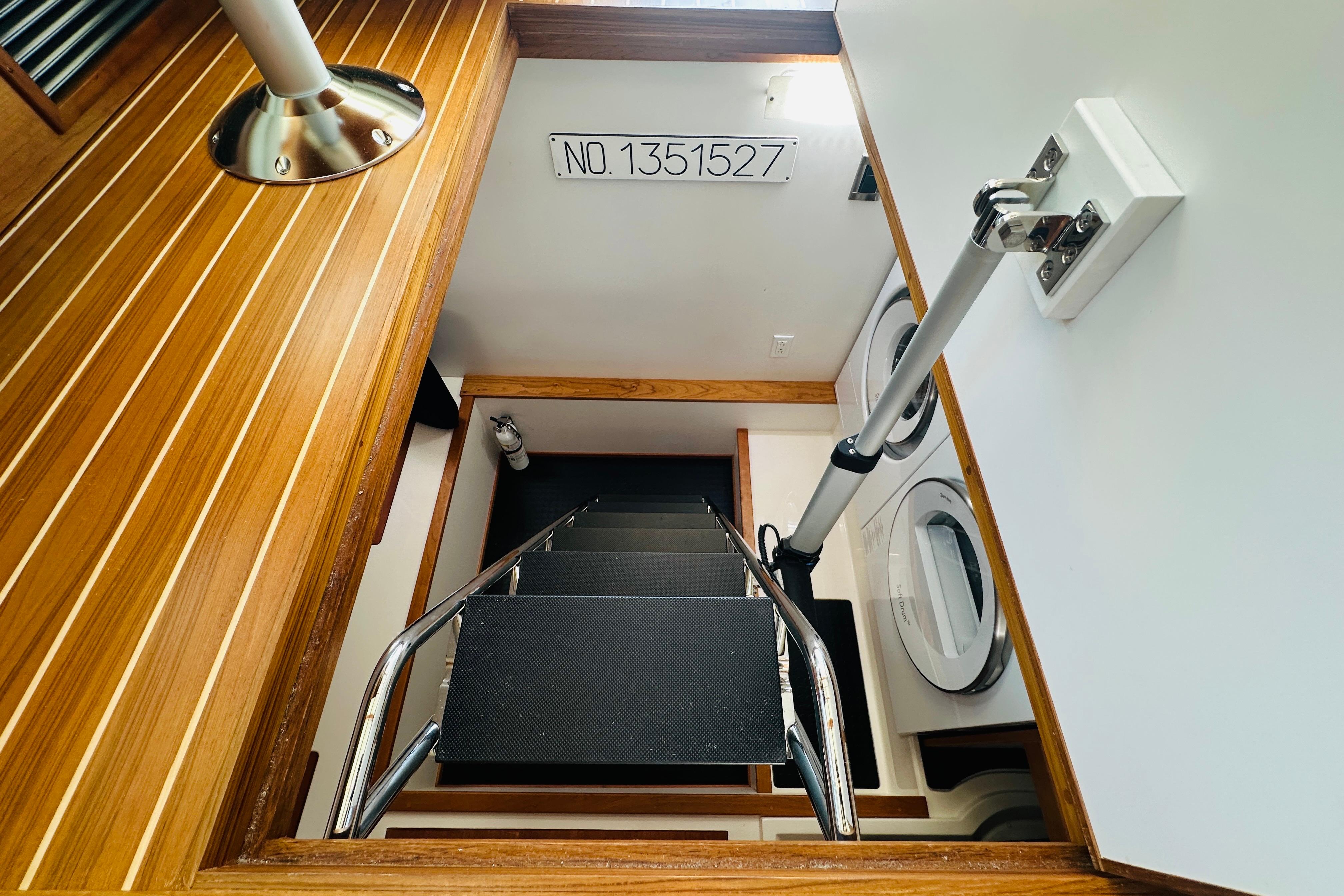 Staircase in 2025 Sabre 48 Salon Express yacht, featuring wood paneling and laundry area.