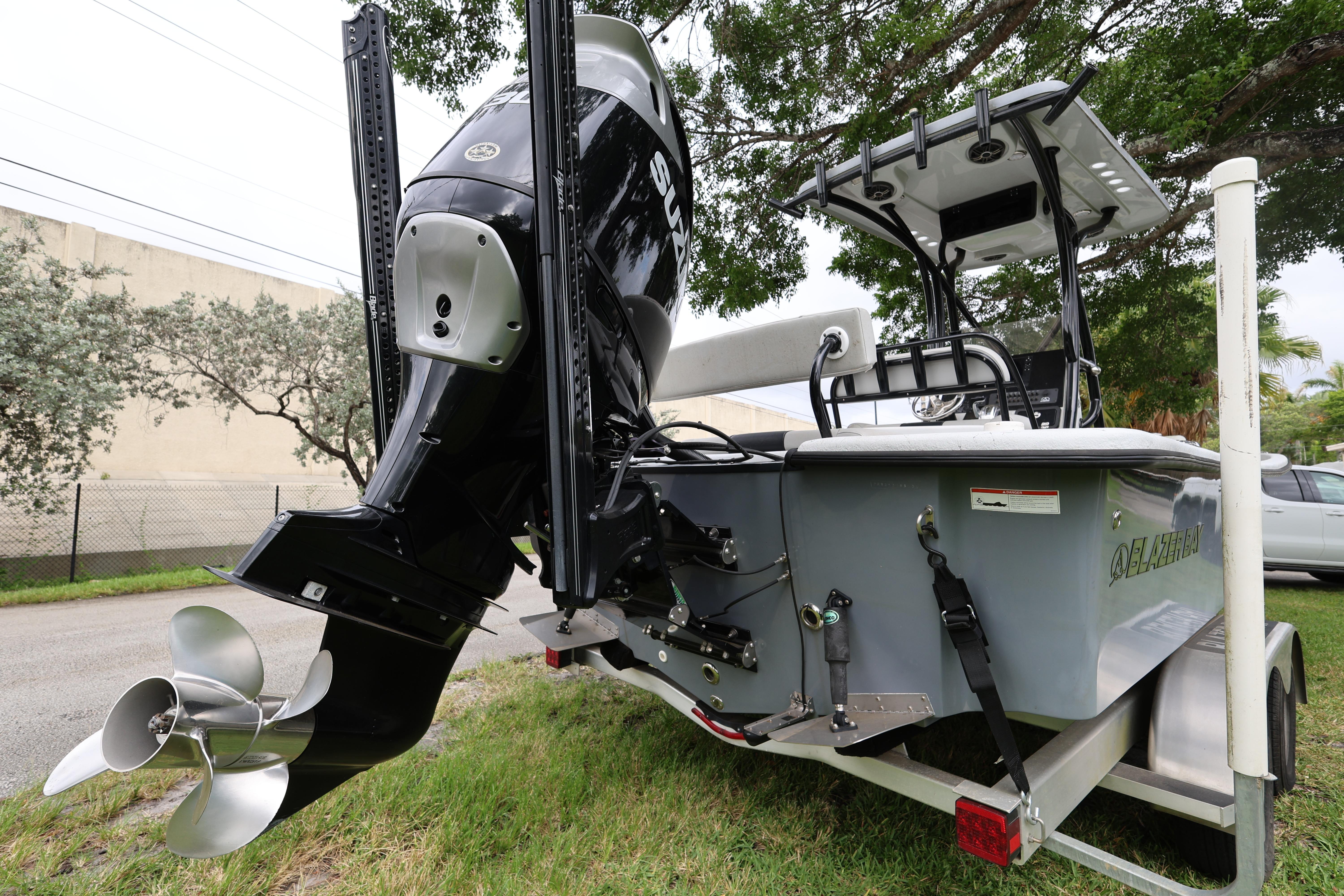 2021 Blazer Bay 2400 boat with powerful outboard motor, parked on a trailer.
