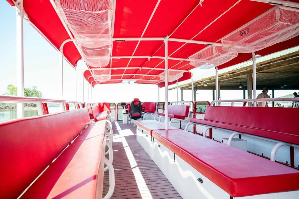 2024 Aloha Pontoon 50' Water Taxi with red seating and canopy, docked by the water.