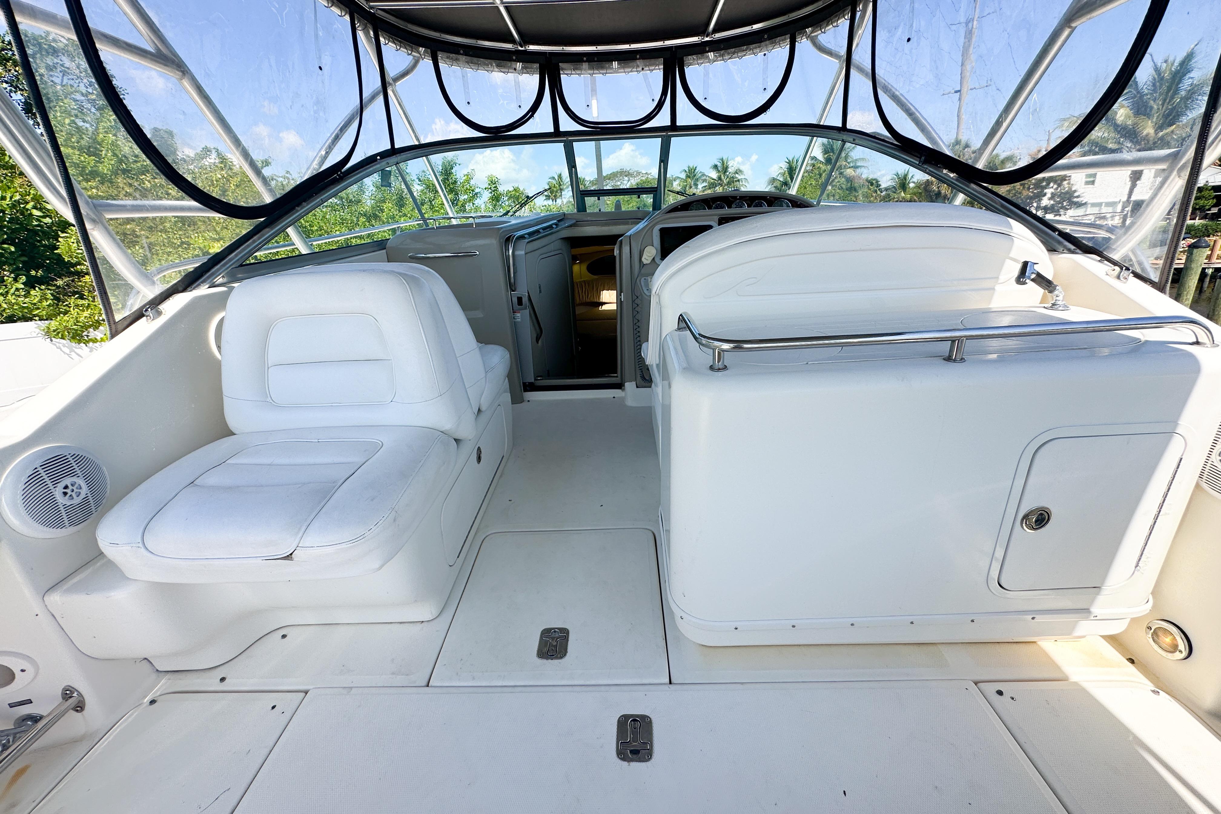 2006 Sea Ray 290 Amberjack boat interior with white seating and clear canopy.