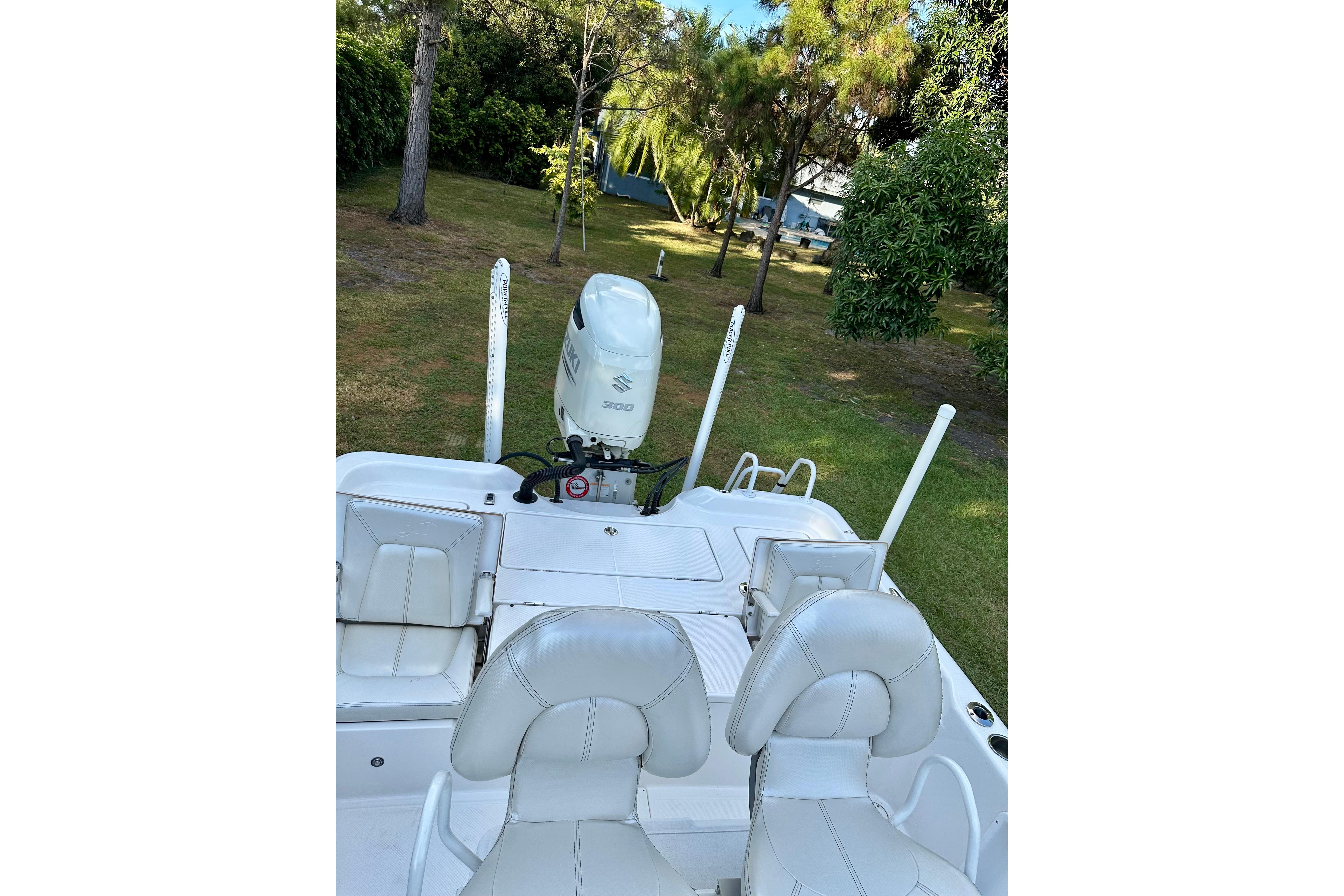 2017 Blue Wave 2400 PureBay boat with Suzuki engine, parked on grass.