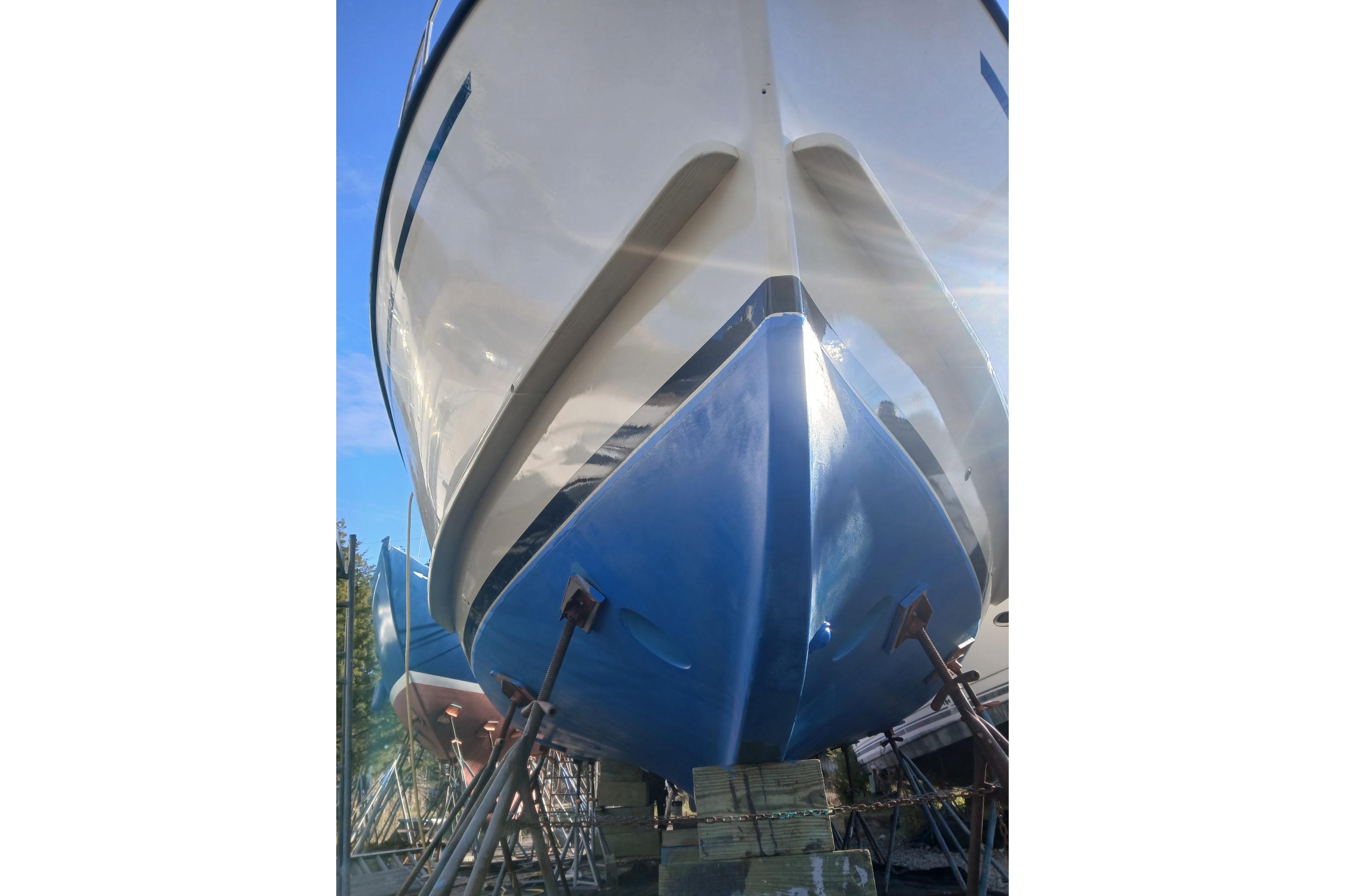 1997 Rosborough Trawler on stands, viewed from below, with blue and white hull.