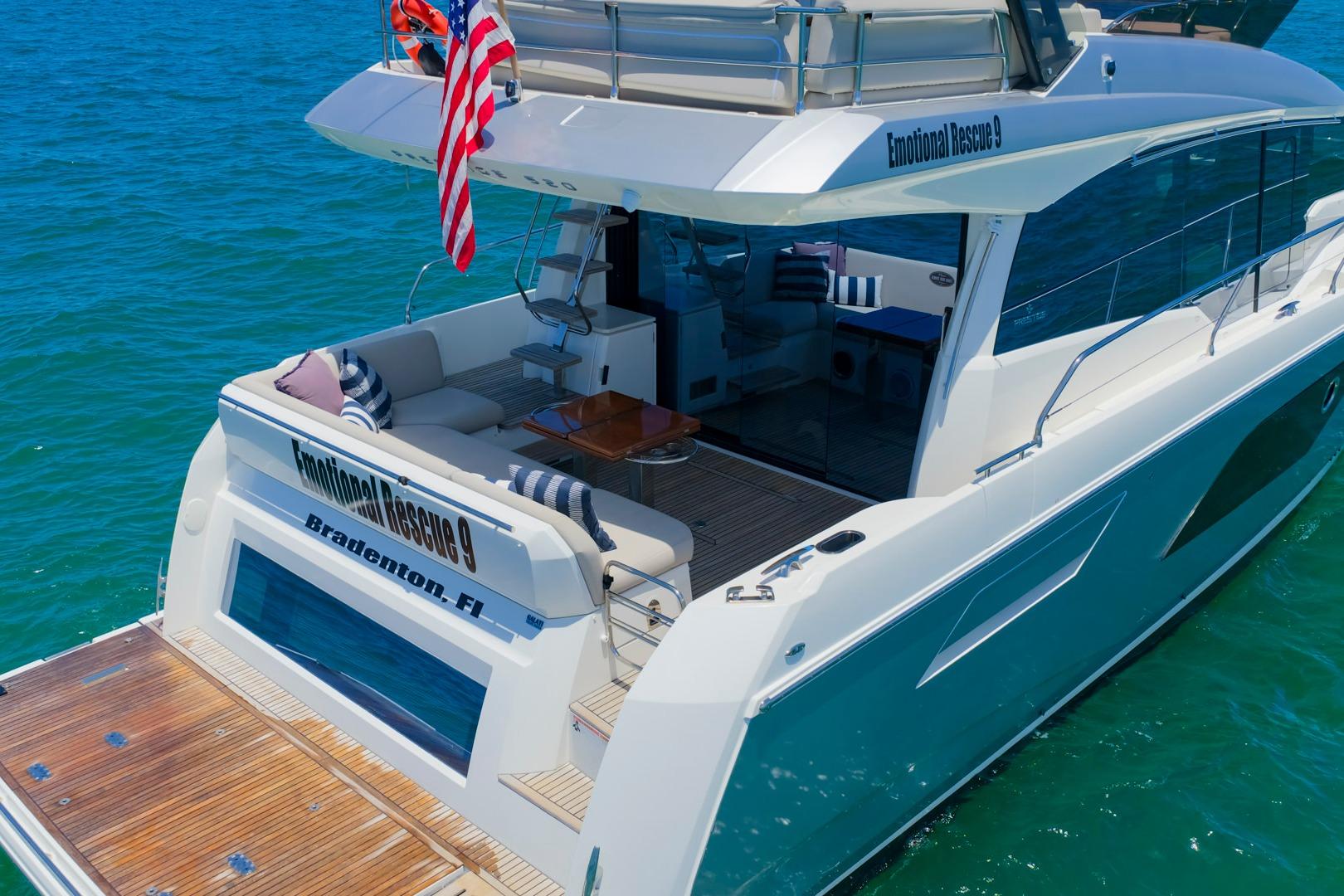 Luxury 2022 Prestige 520 yacht on clear blue water, featuring spacious deck and elegant design.