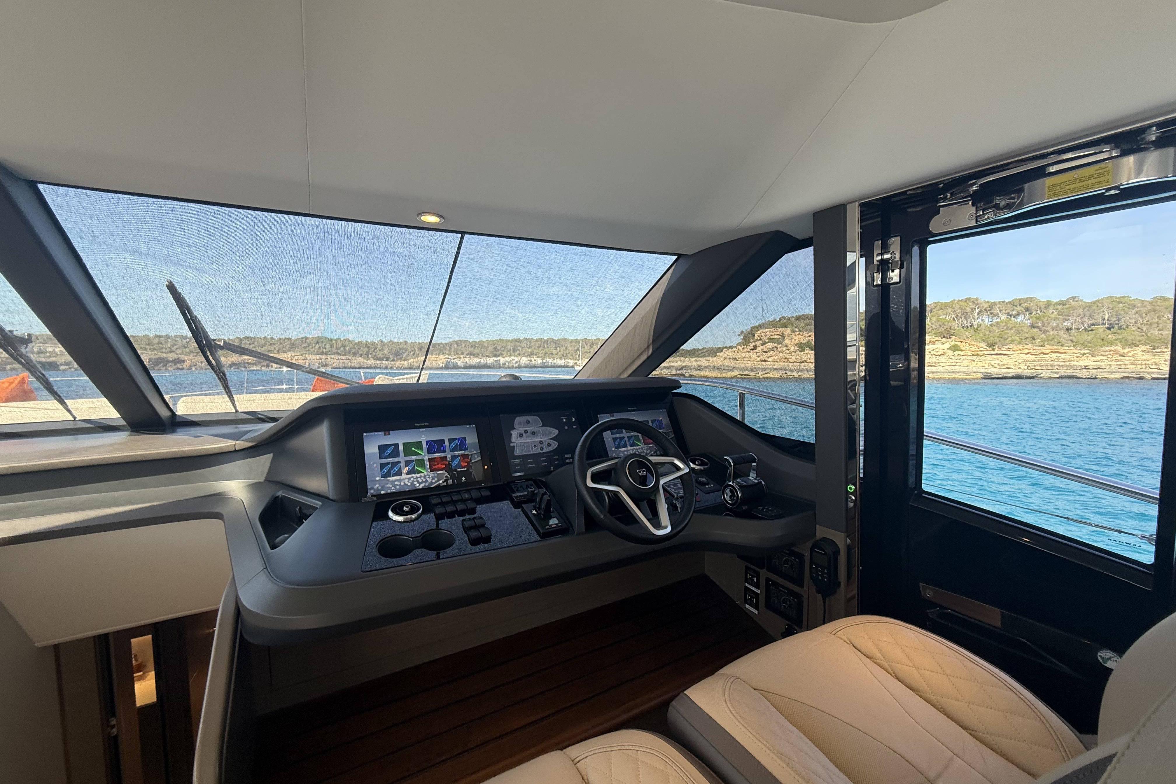 Interior view of 2025 Princess Y72 yacht cockpit with modern controls and scenic ocean backdrop.