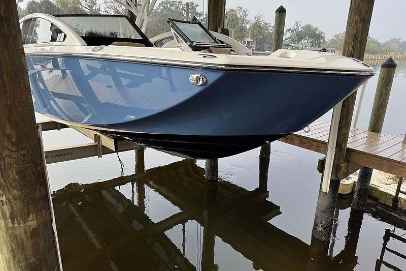 2023 Yamaha 275SDX boat docked, featuring sleek blue hull design.