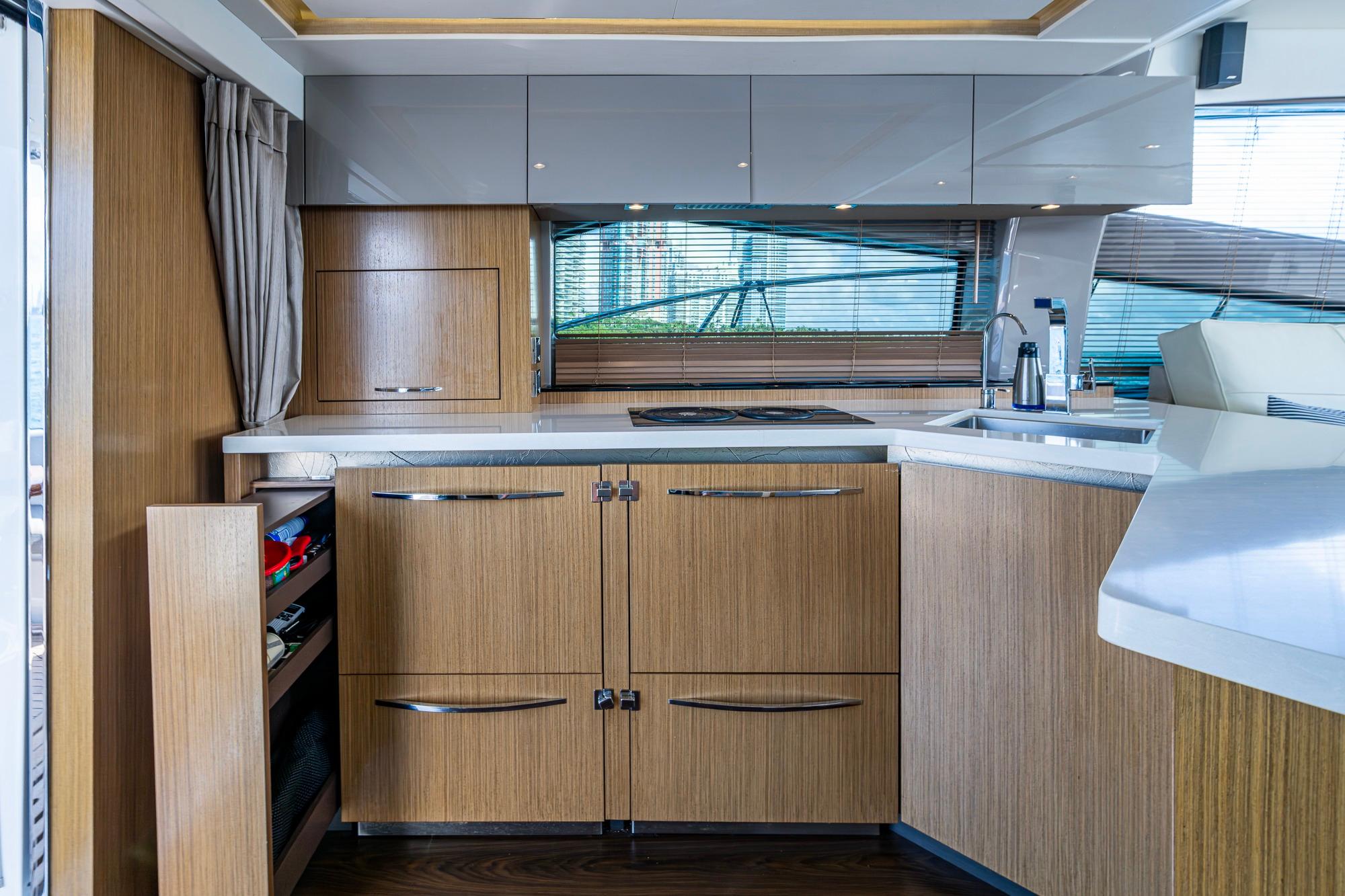 Luxurious 2018 Sea Ray L550 Fly yacht kitchen with modern wood cabinetry and sleek countertops.