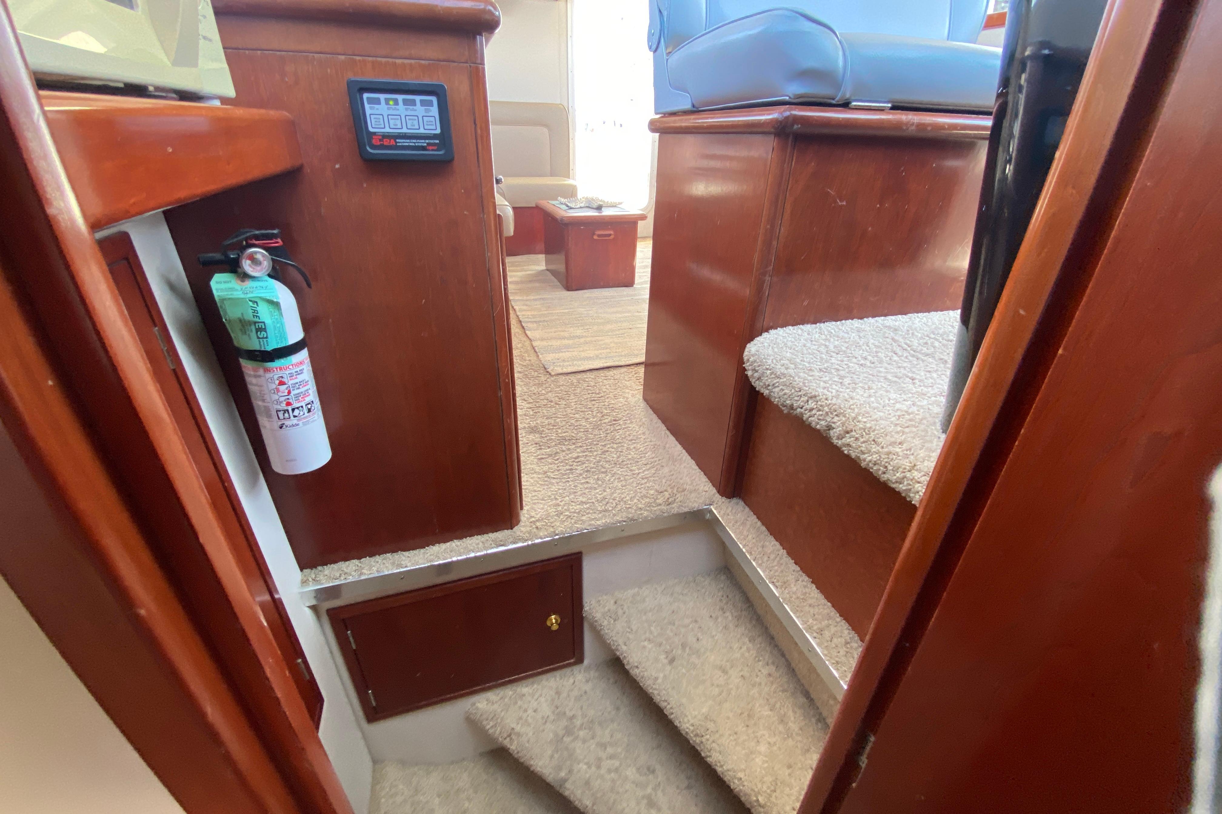 Interior of 2003 Zeta 36 boat with carpeted stairs and fire extinguisher.