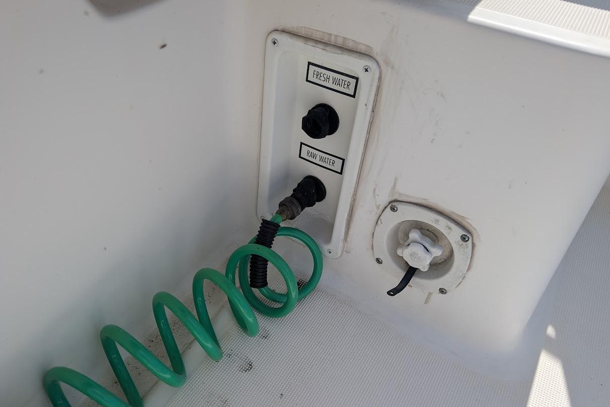 Water connections on a 2000 Pursuit 3400 Express boat, featuring fresh and raw water outlets.