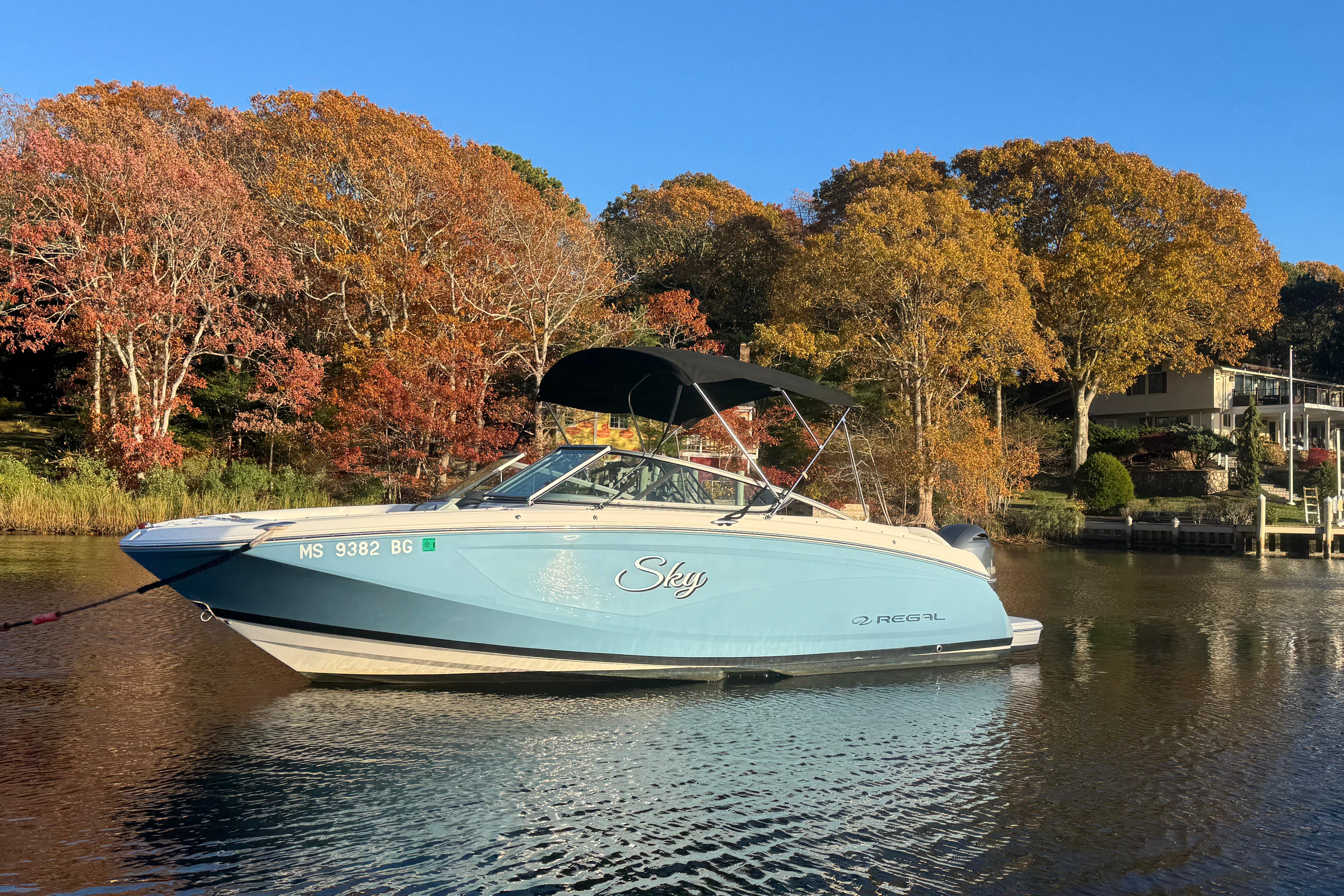 2017 Regal 23 OBX boat on calm water, surrounded by autumn trees.