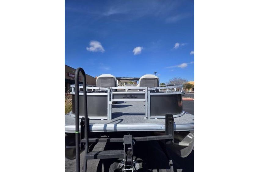 2026 Sun Tracker Bass Buggy 16 XL Select pontoon boat under clear blue sky.