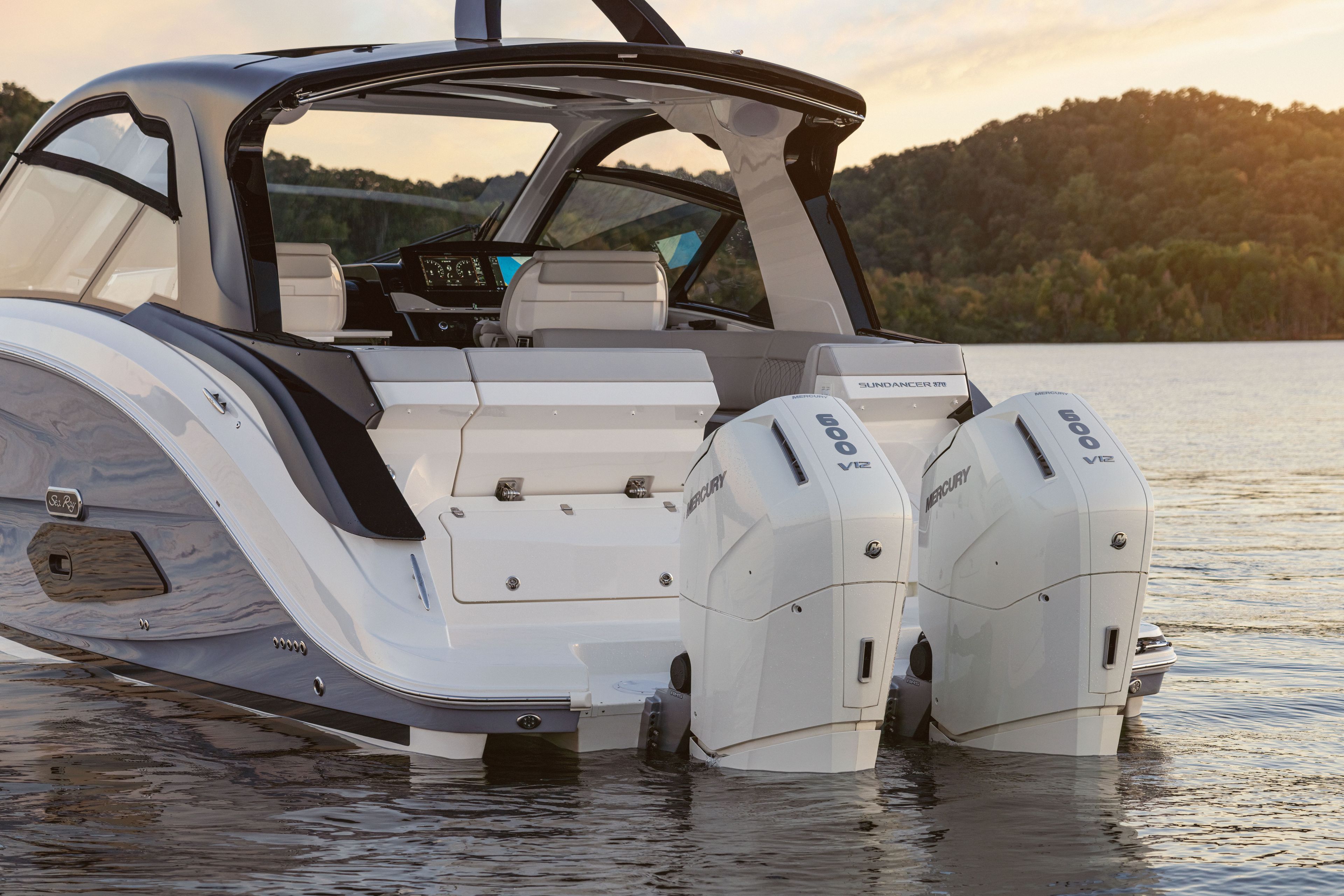 A 2026 Sea Ray Sundancer 370 Outboard with twin outboard engines on calm water.