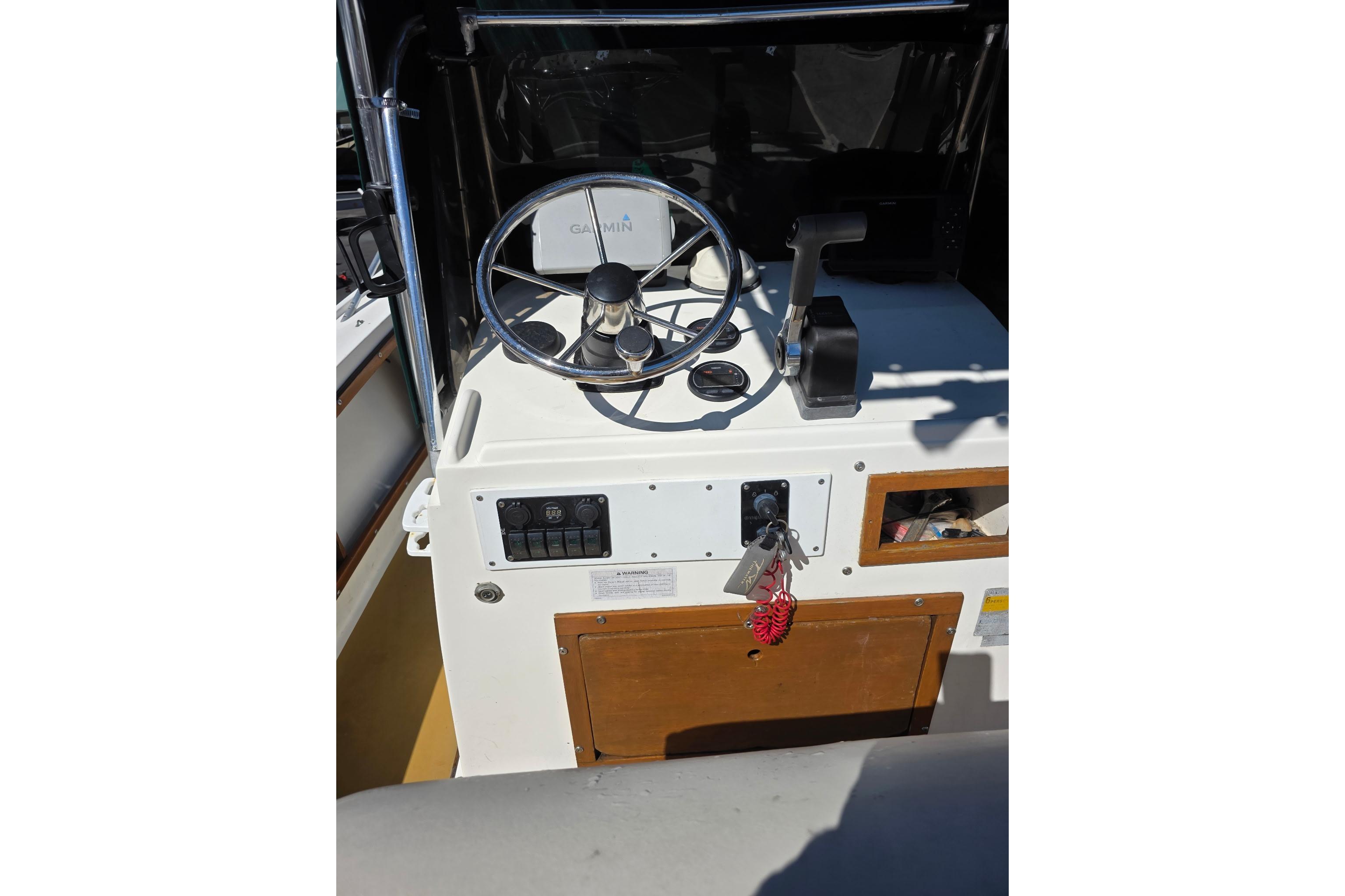 1982 Mako 20 Center Console boat dashboard with steering wheel and controls.