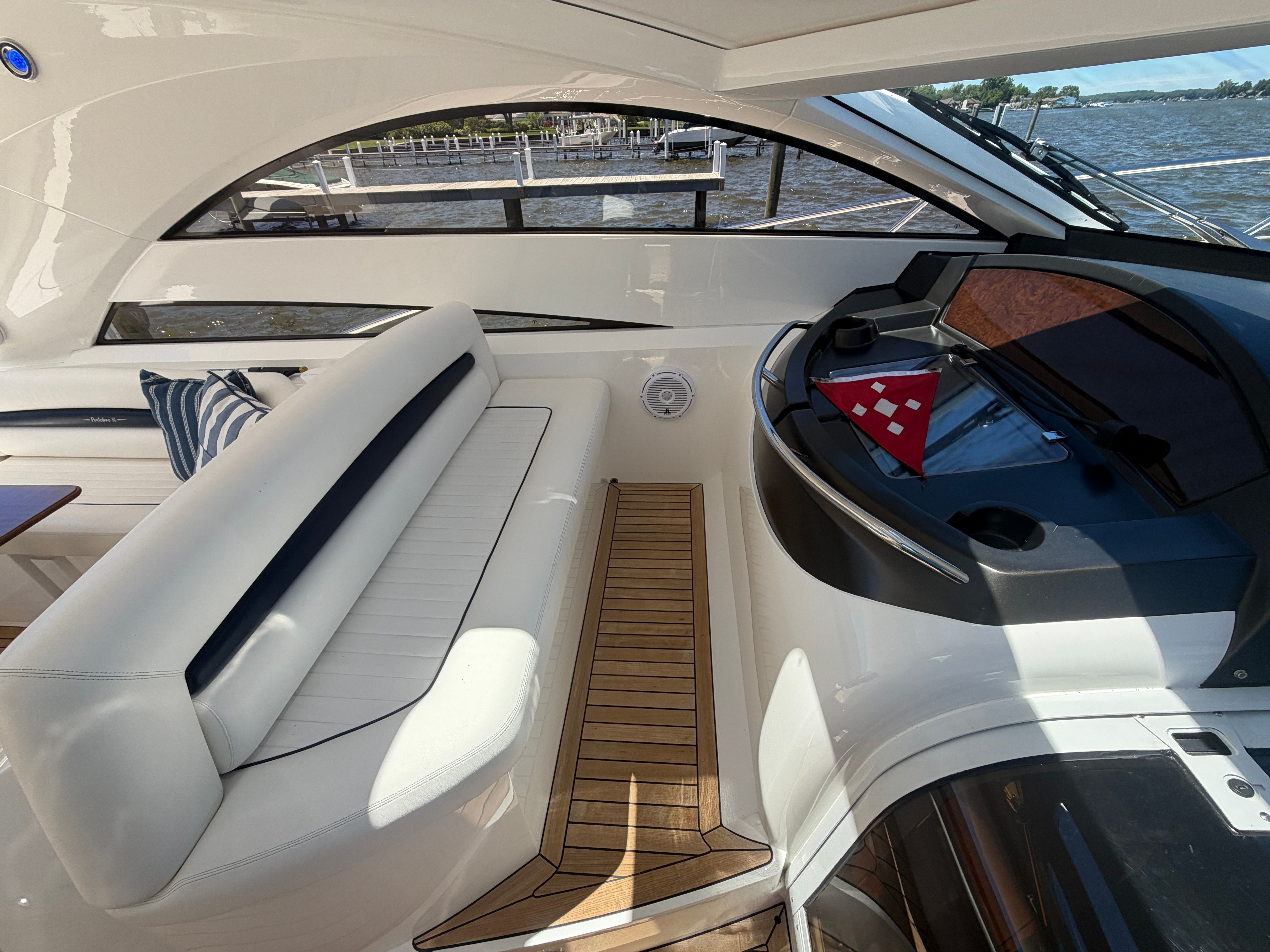 Interior of a Sunseeker Portofino 53 with white seating and wooden flooring.