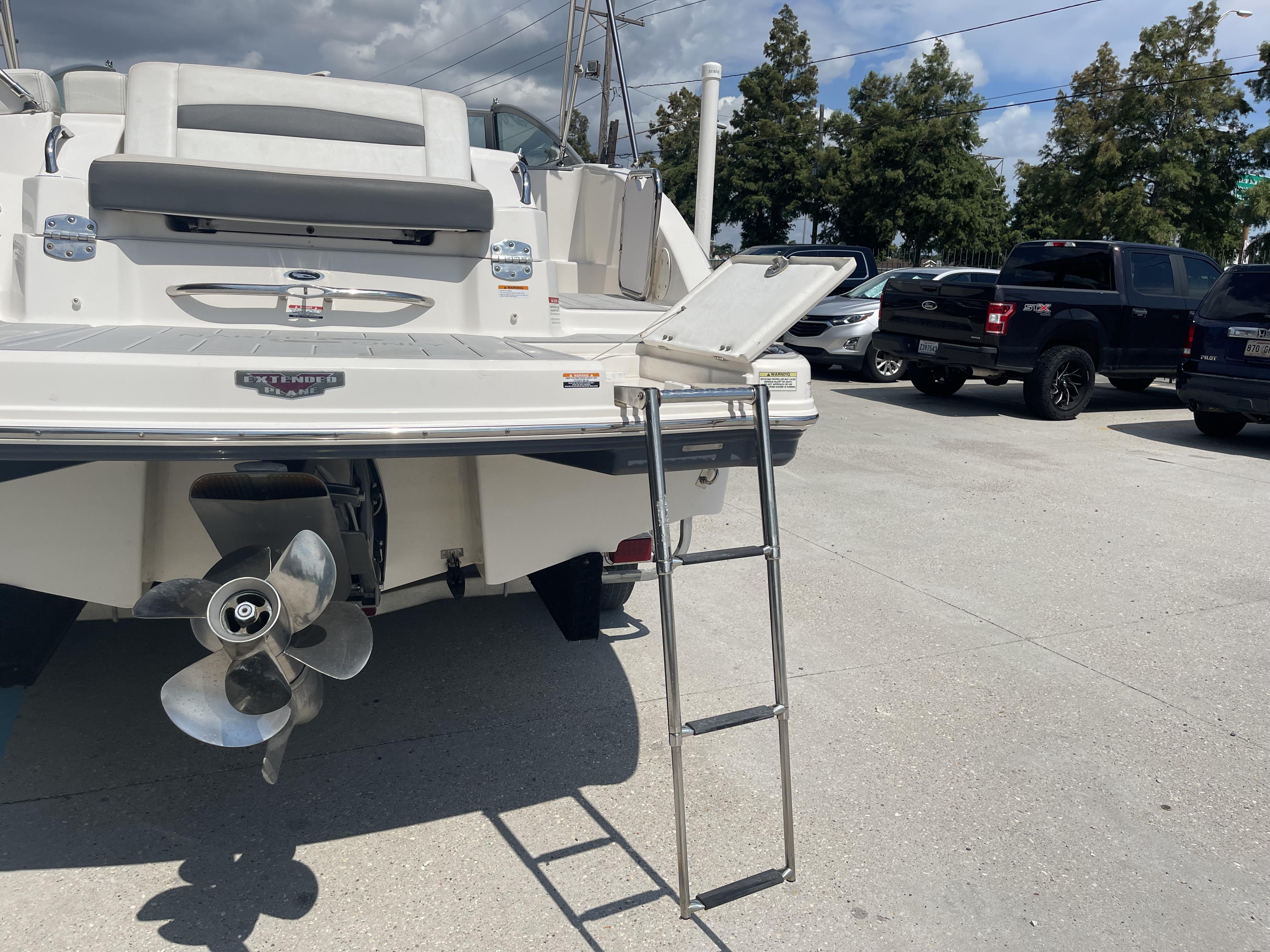 2014 Chaparral Sunesta 224 boat with ladder and propeller, parked outdoors.
