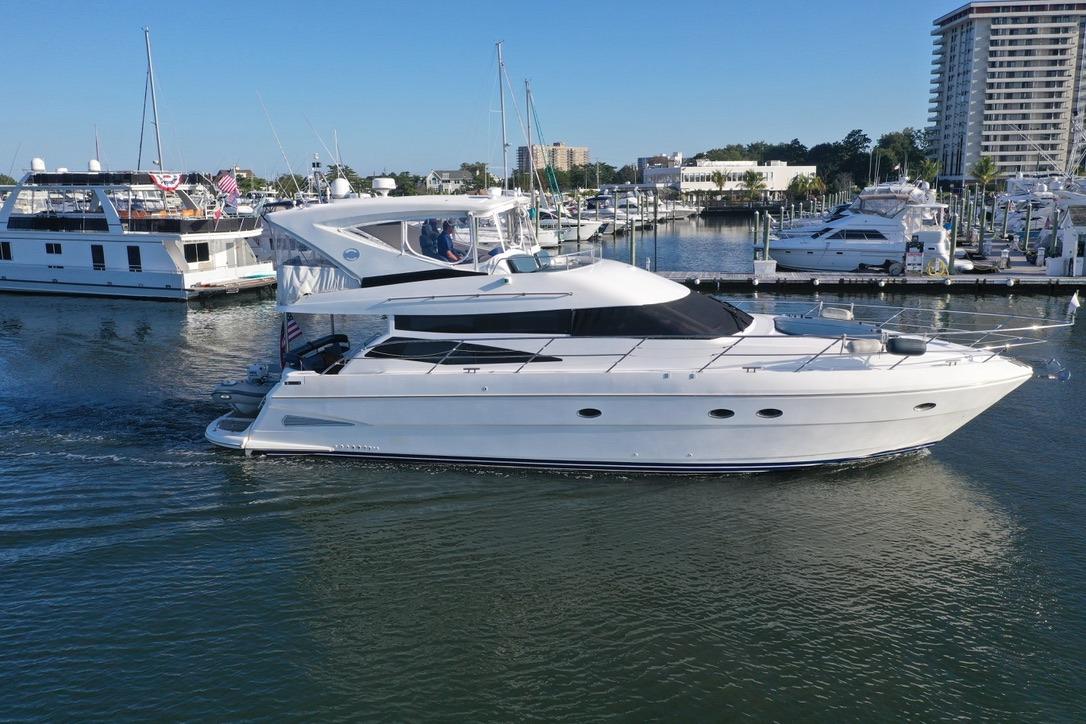 2005 Neptunus 56 Flybridge yacht cruising in a marina with nearby boats.