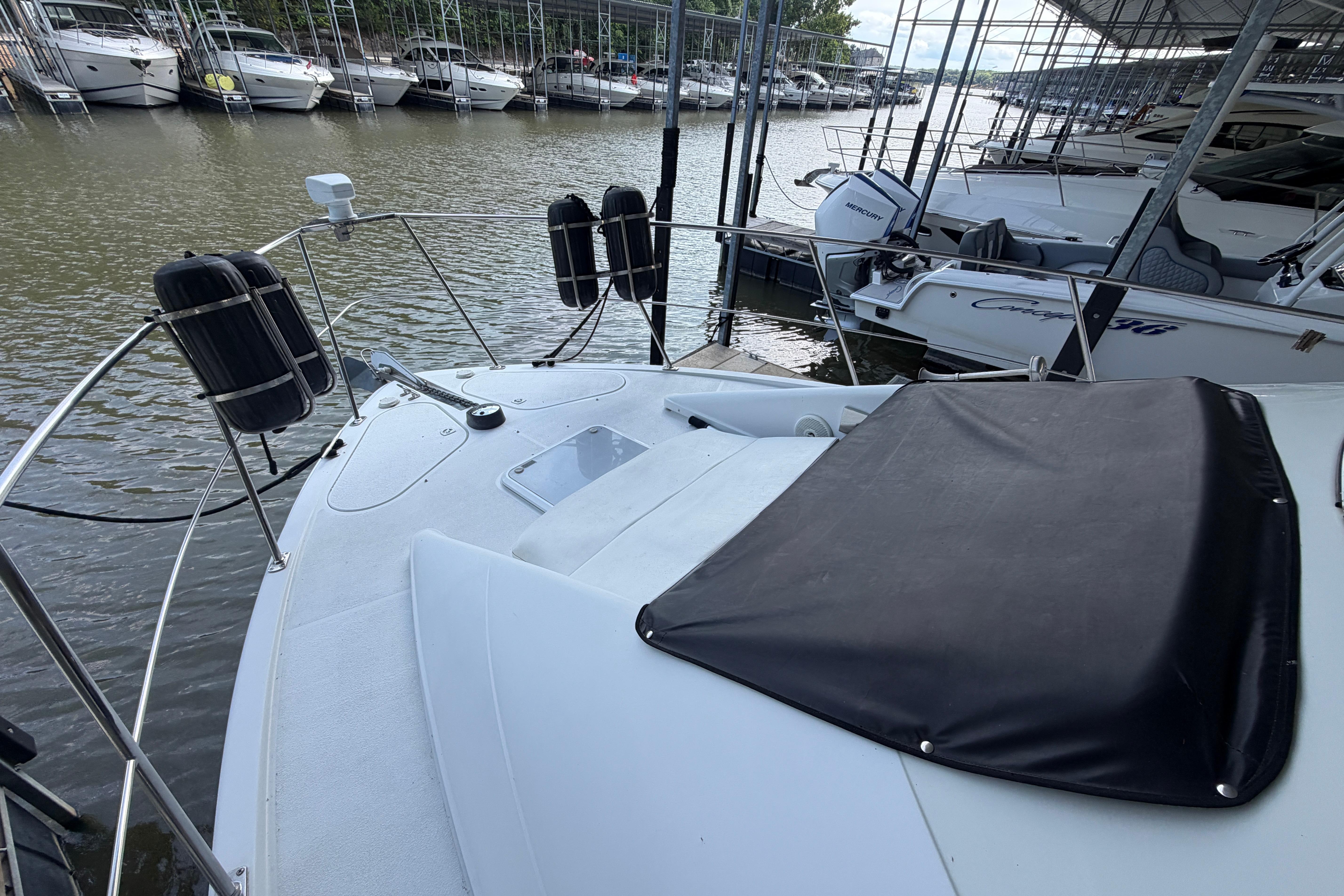 2000 Carver 350 Mariner yacht docked at marina with protective covers.