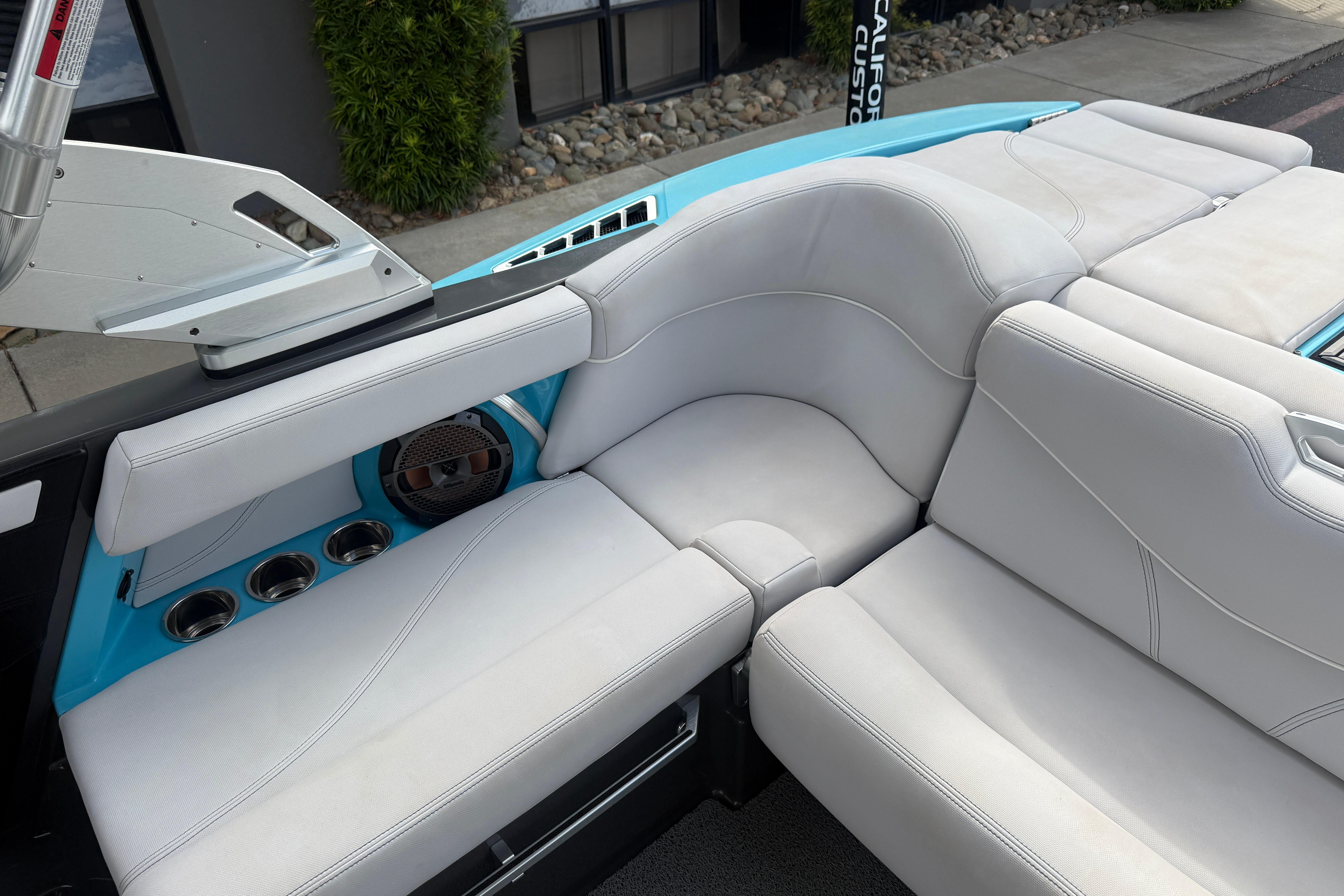 2018 MasterCraft XT21 boat interior with white leather seats and cup holders.