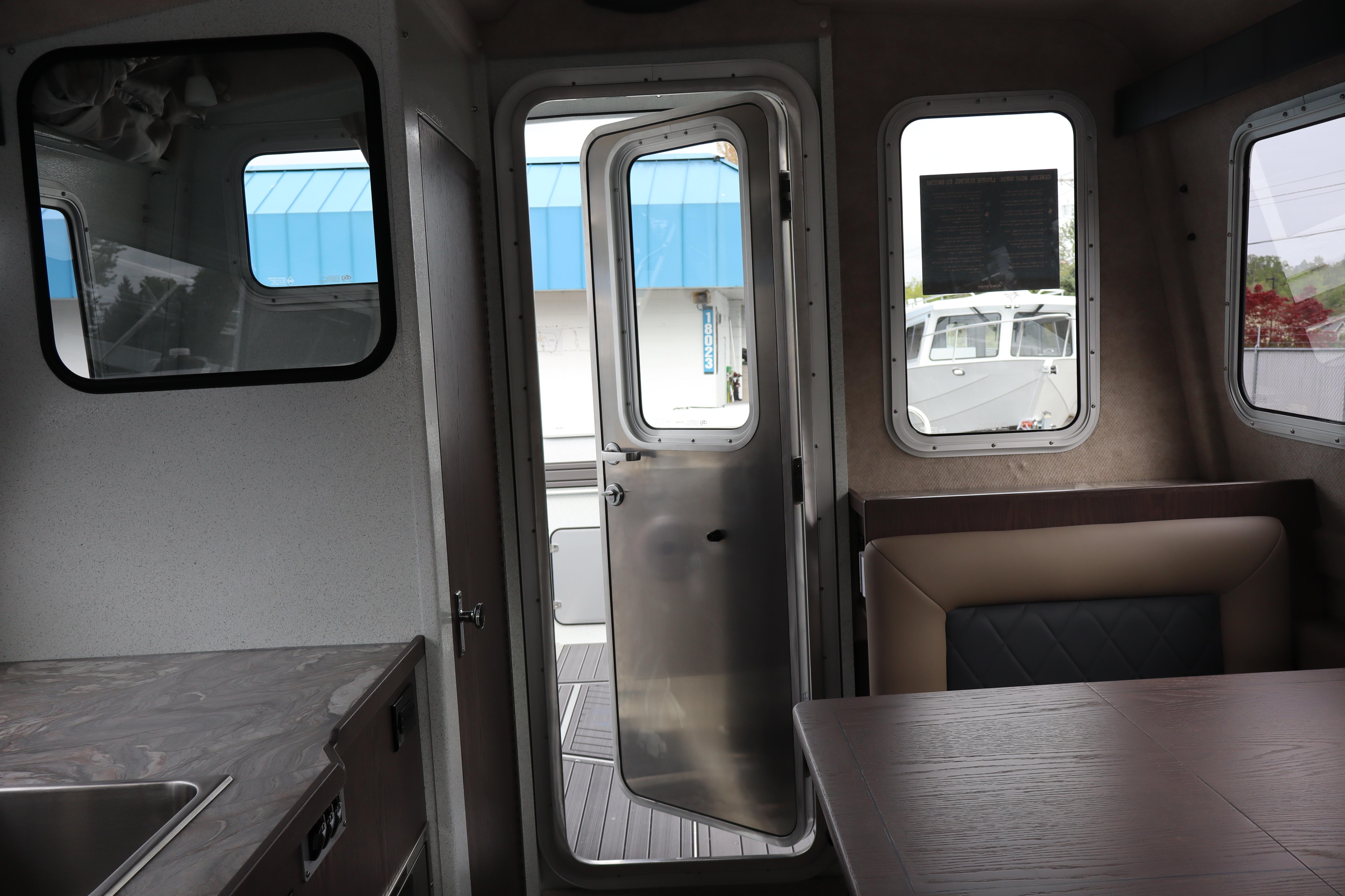 Interior view of 2026 KingFisher 3025 XRS boat, featuring seating and open door.