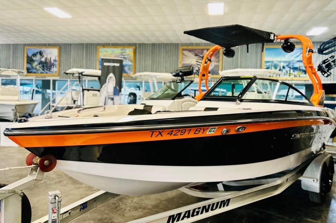 2013 Nautique Super Air Nautique 230 boat on trailer in showroom.